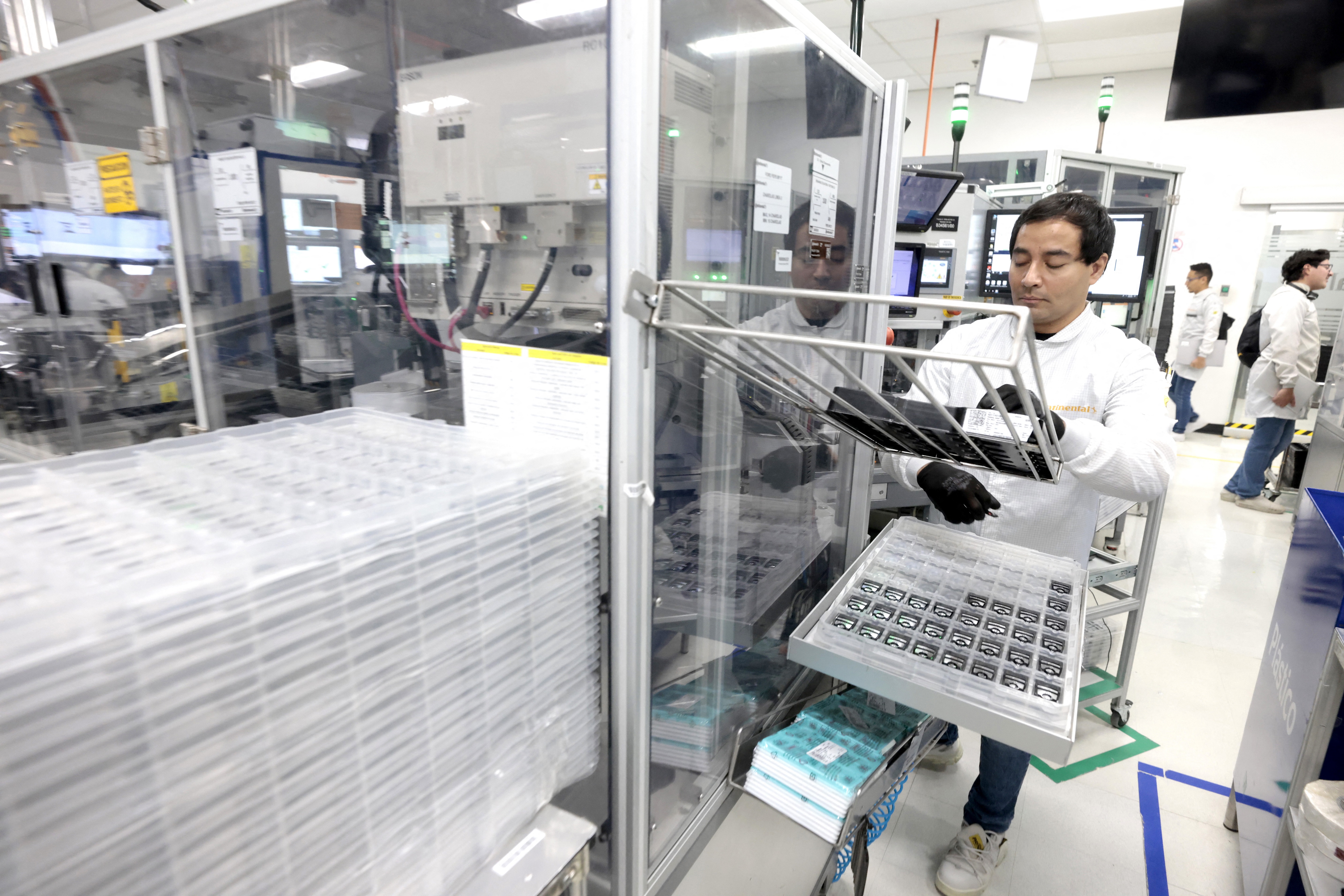 A worker assembles electronic car keys at a manufacturing plant in Tlajomulco de Zuniga, Jalisco State, Mexico. The production of key fobs used by millions each day is an example of the benefits of the USMCA free trade agreement between the United States, Canada, and Mexico. Photo by Ulises Ruiz, AFP