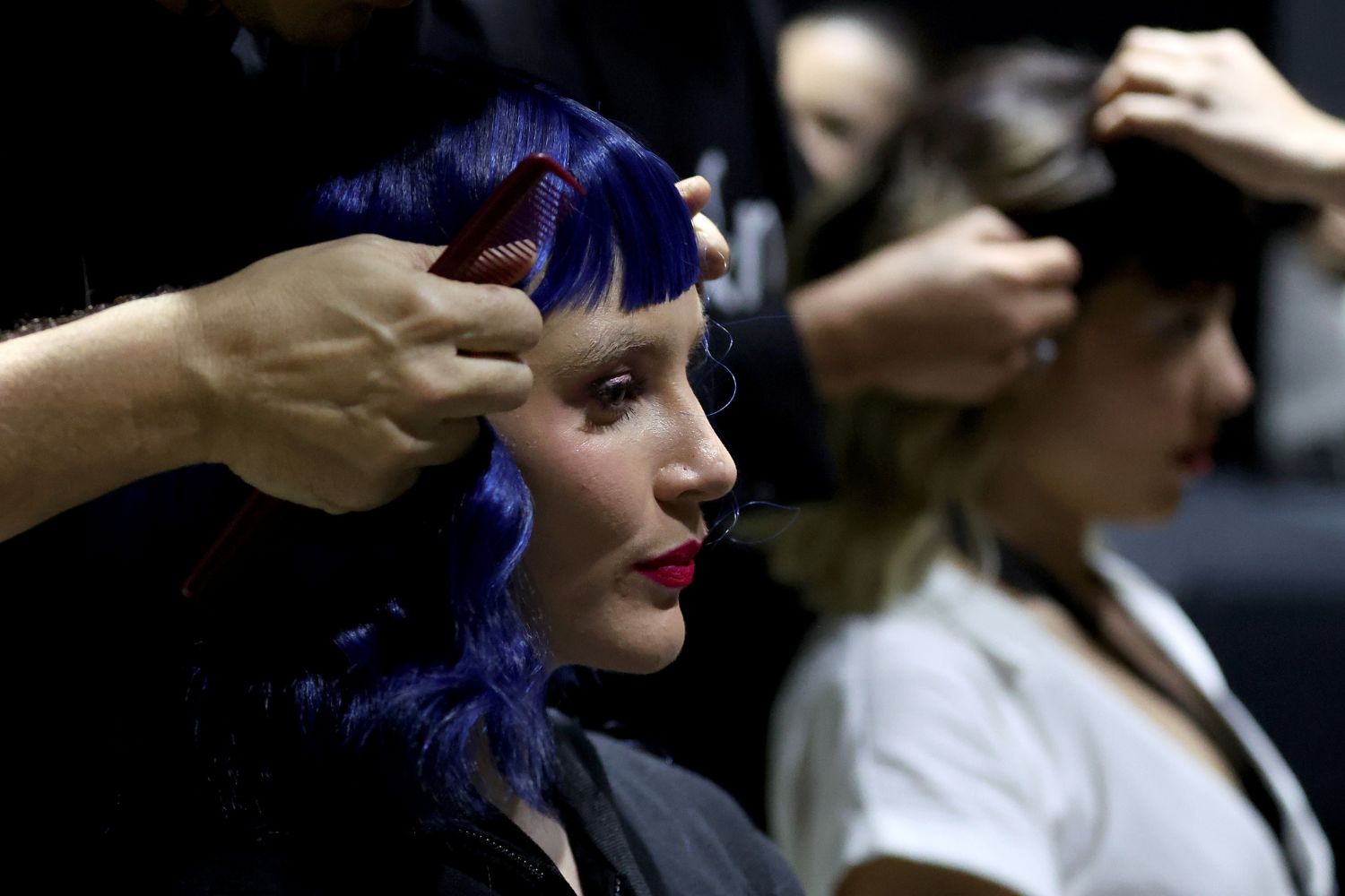 Award-winning hairstylist and founder of D&M, Danny Pato adjusts a brightly hued wig backstage at Kathryn Wilson. Photo / Getty Images