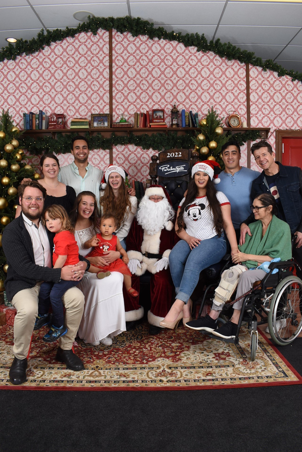 Simon and Jodi Barnett (in wheelchair, far right) have 30 years of Christmas photos at Ballantynes in Christchurch. This photo, with their four daughters, their partners and grandchildren was taken last Christmas. 
