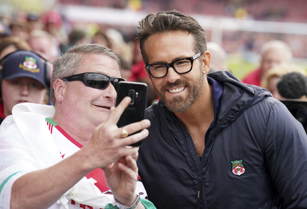 Wrexham co-owner Ryan Reynolds poses with fans ahead of the National League football match between Wrexham and Boreham Wood which secured Wrexham's promotion. Photo / AP