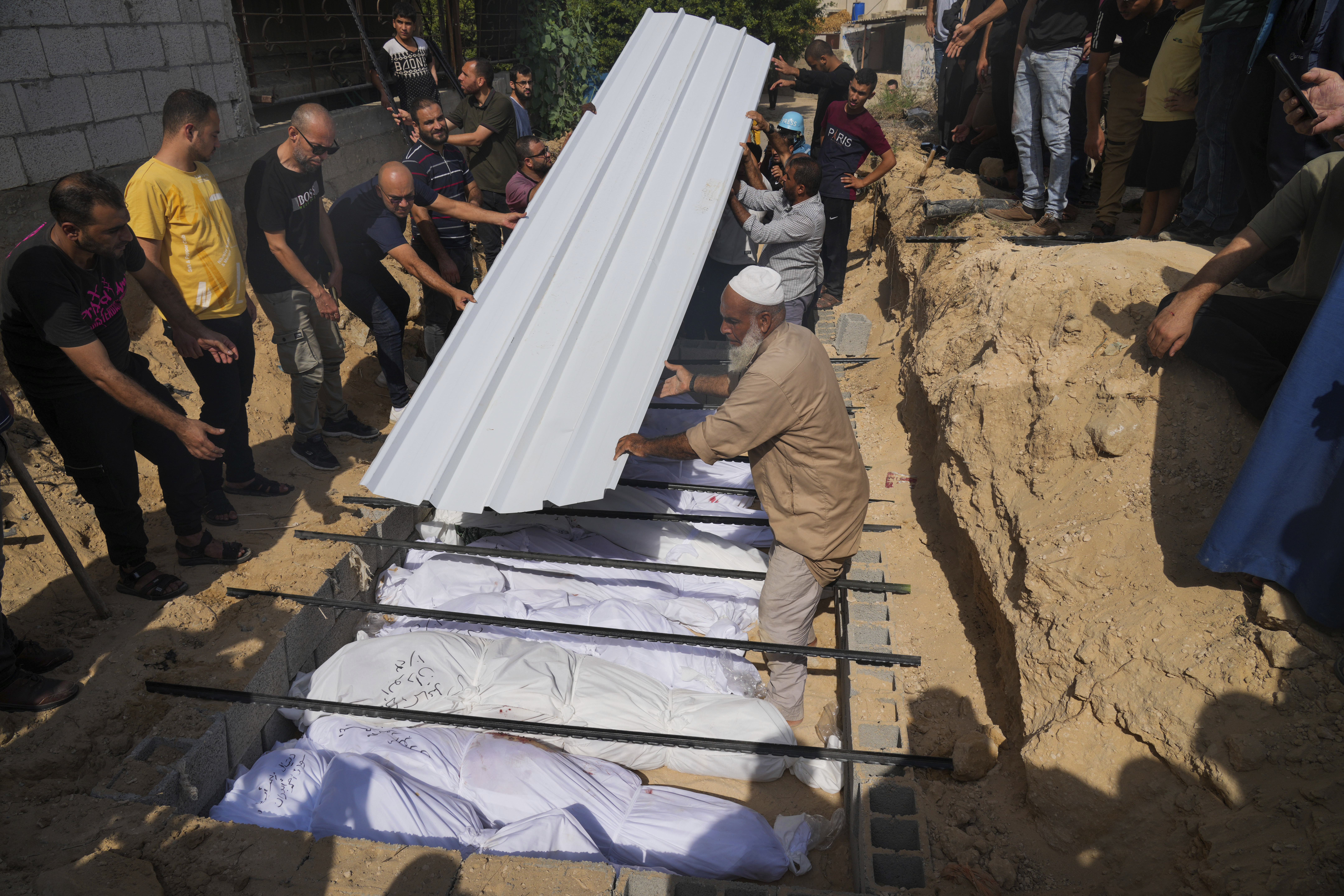 Palestinians bury the bodies of their relatives killed in the Israeli bombardment of the Gaza Strip, at a cemetery in Deir Al-Balah, Gaza. Photo / AP