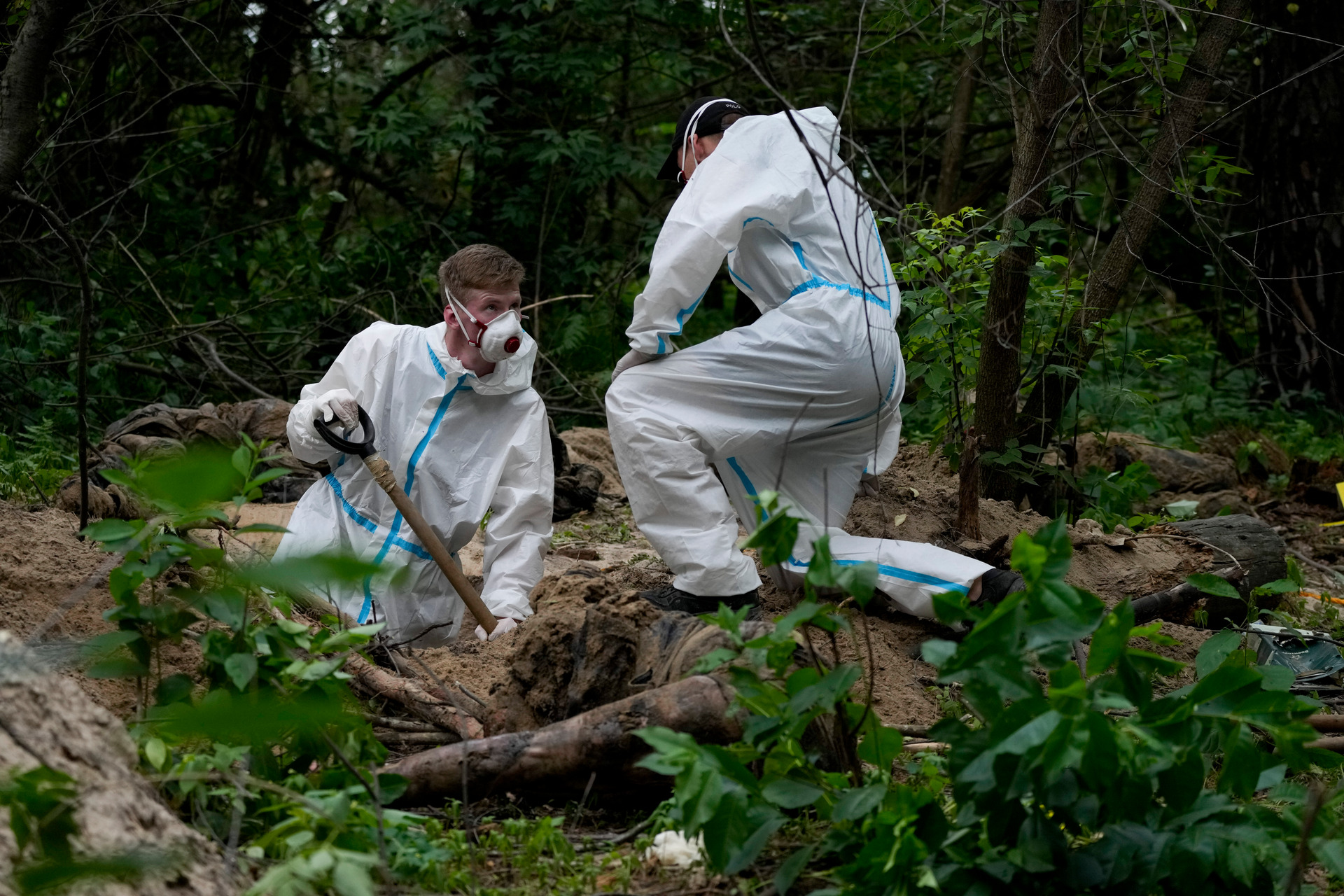 Members of an extraction crew work during an exhumation at a mass grave near Bucha, on the outskirts of Kyiv, Ukraine, in June.  Photo / AP