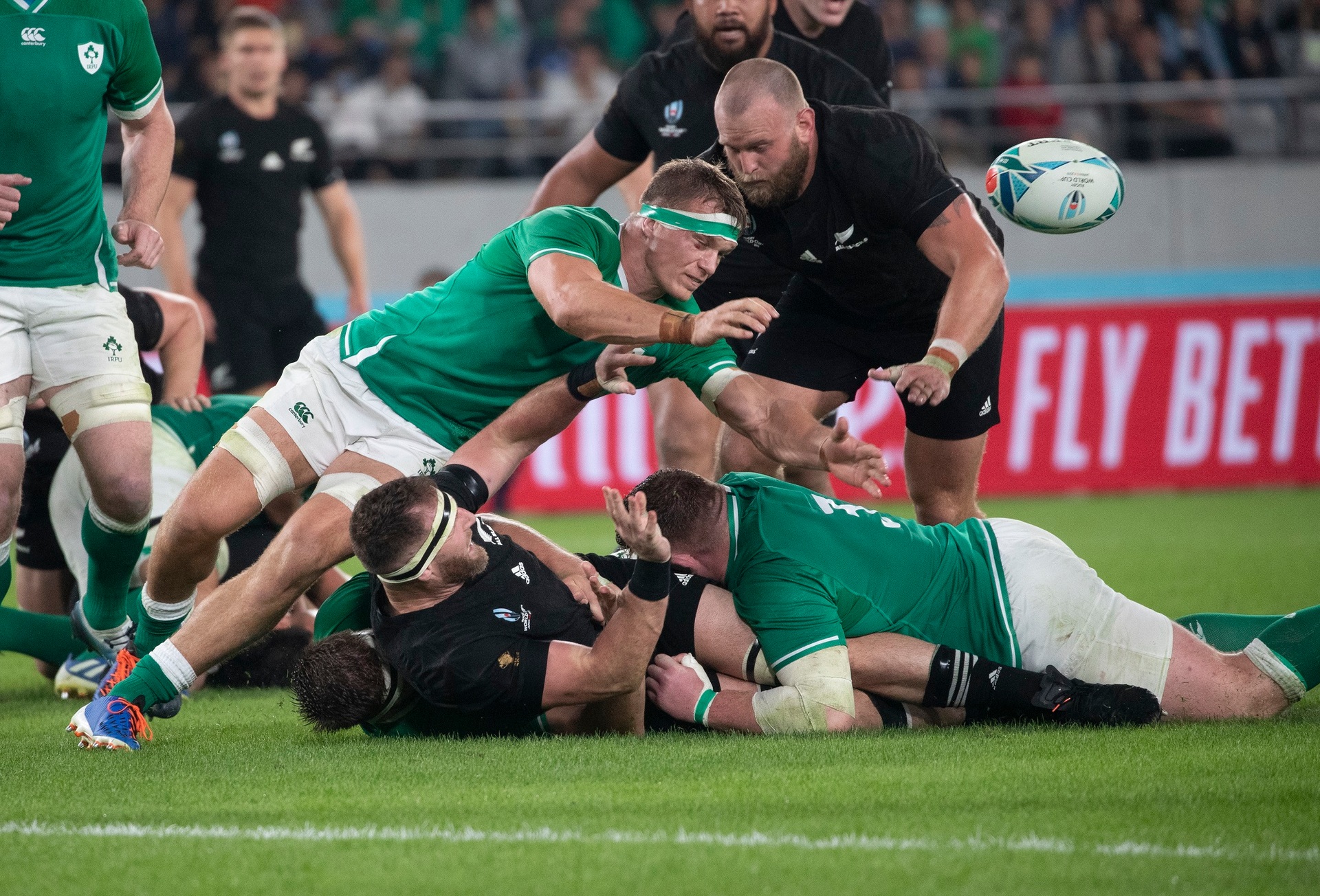 All Blacks captain Kieran Read gets a pass away with three Irish defenders around. Photo / Mark Mitchell