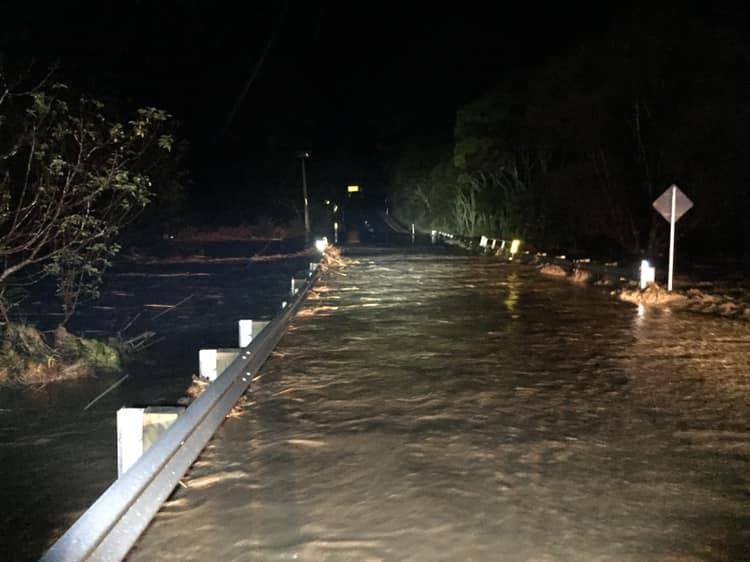Water was surging over South Head Road from the local river. Photo / Helensville Volunteer Fire Brigade