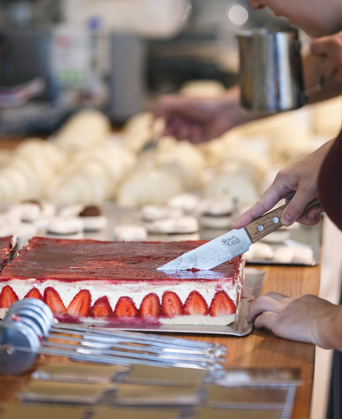 Driss slices a strawberry tart.