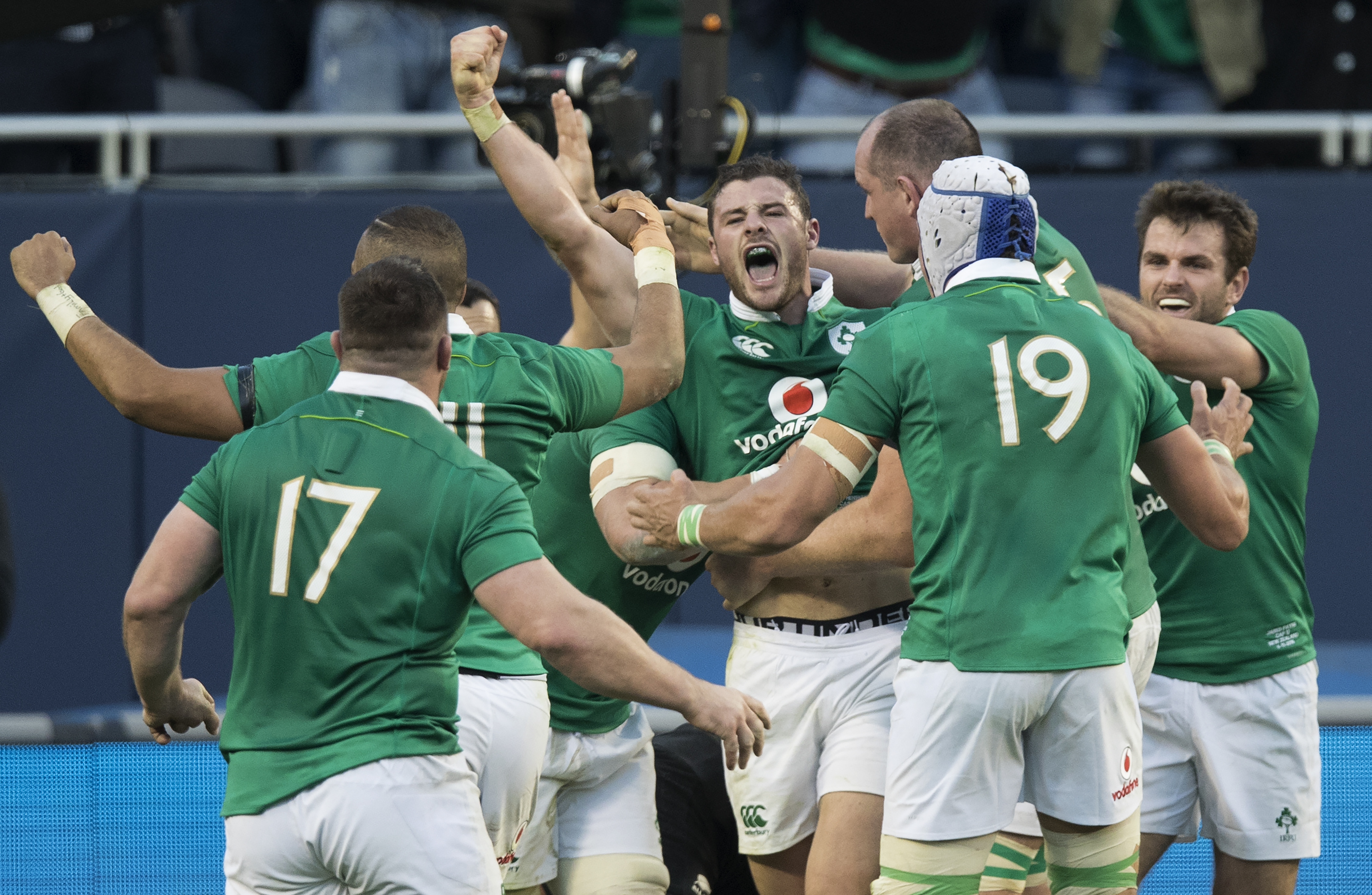Ireland gather around second five-eighth Robbie Henshaw after he scored against the All Blacks at Soldier Field. Photo / Brett Phibbs
