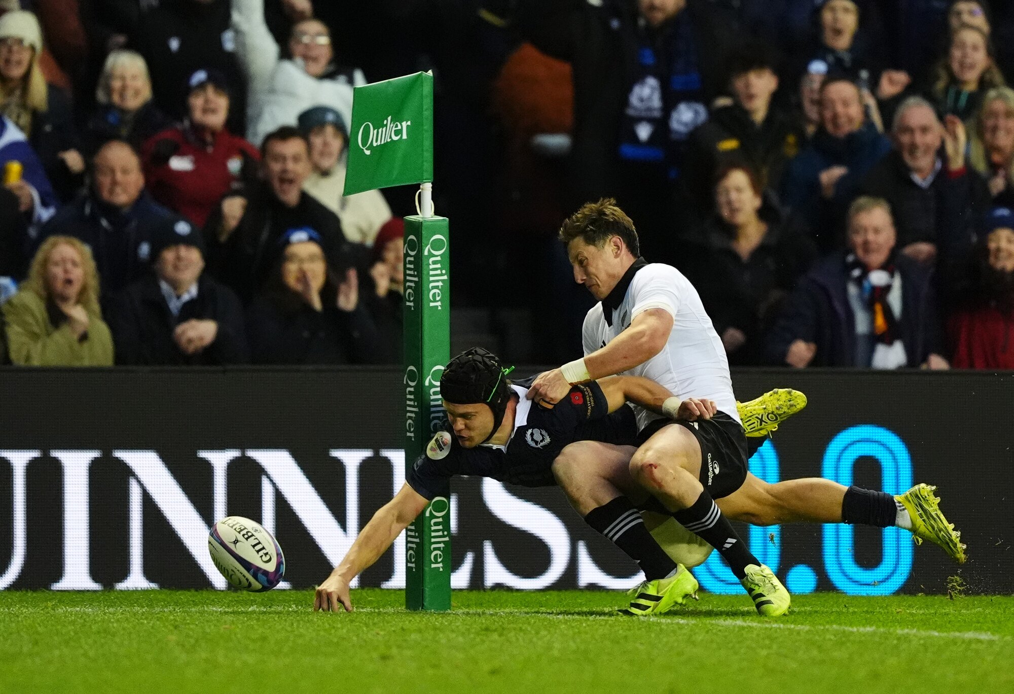 Scotland's Darcy Graham spills the ball in the challenge of All Blacks halfback Cam Roigard, at Murrayfield.  Photo / Getty Images