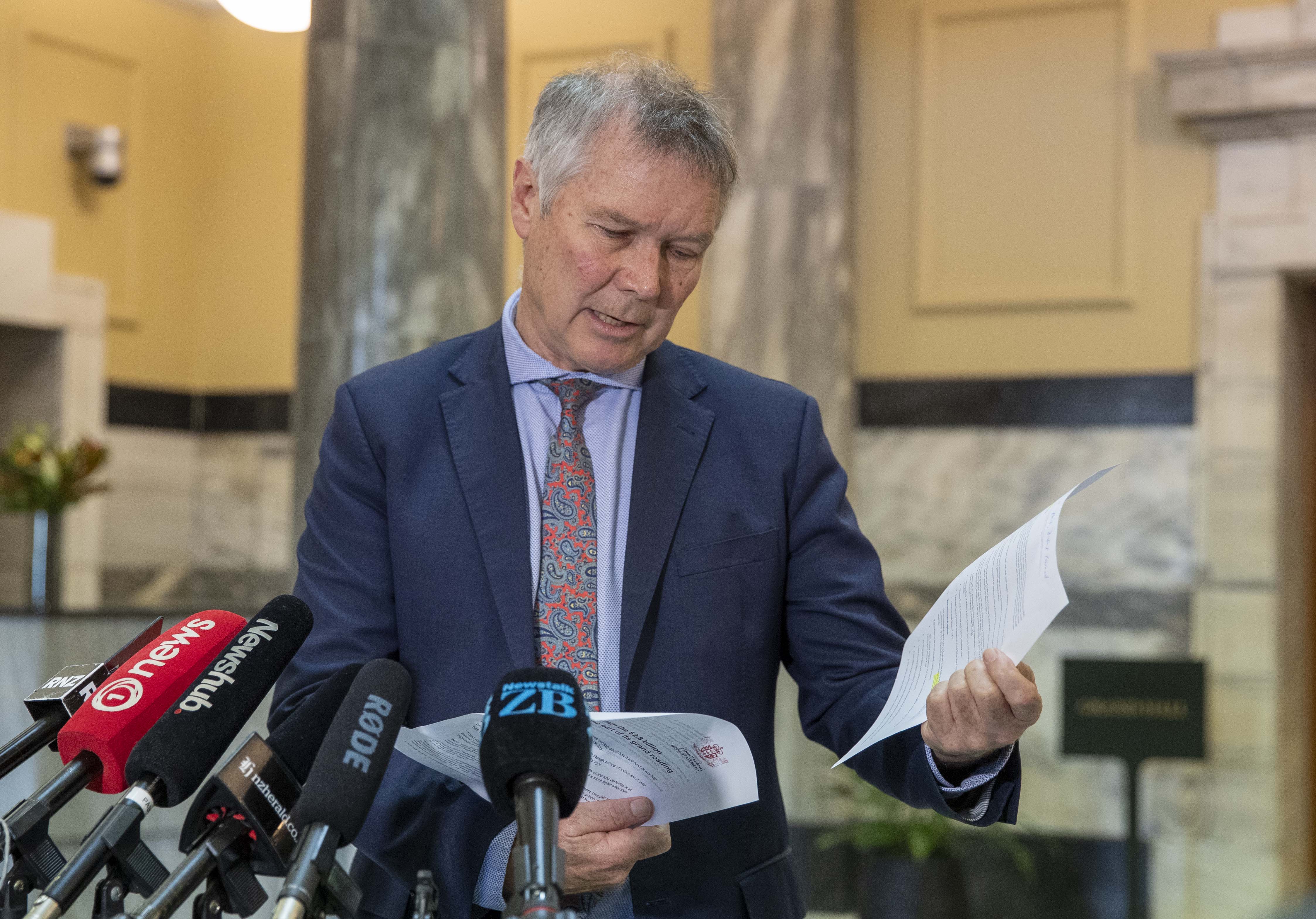 Transport Minister David Parker leafing through the Government's costings. Photo / Mark Mitchell