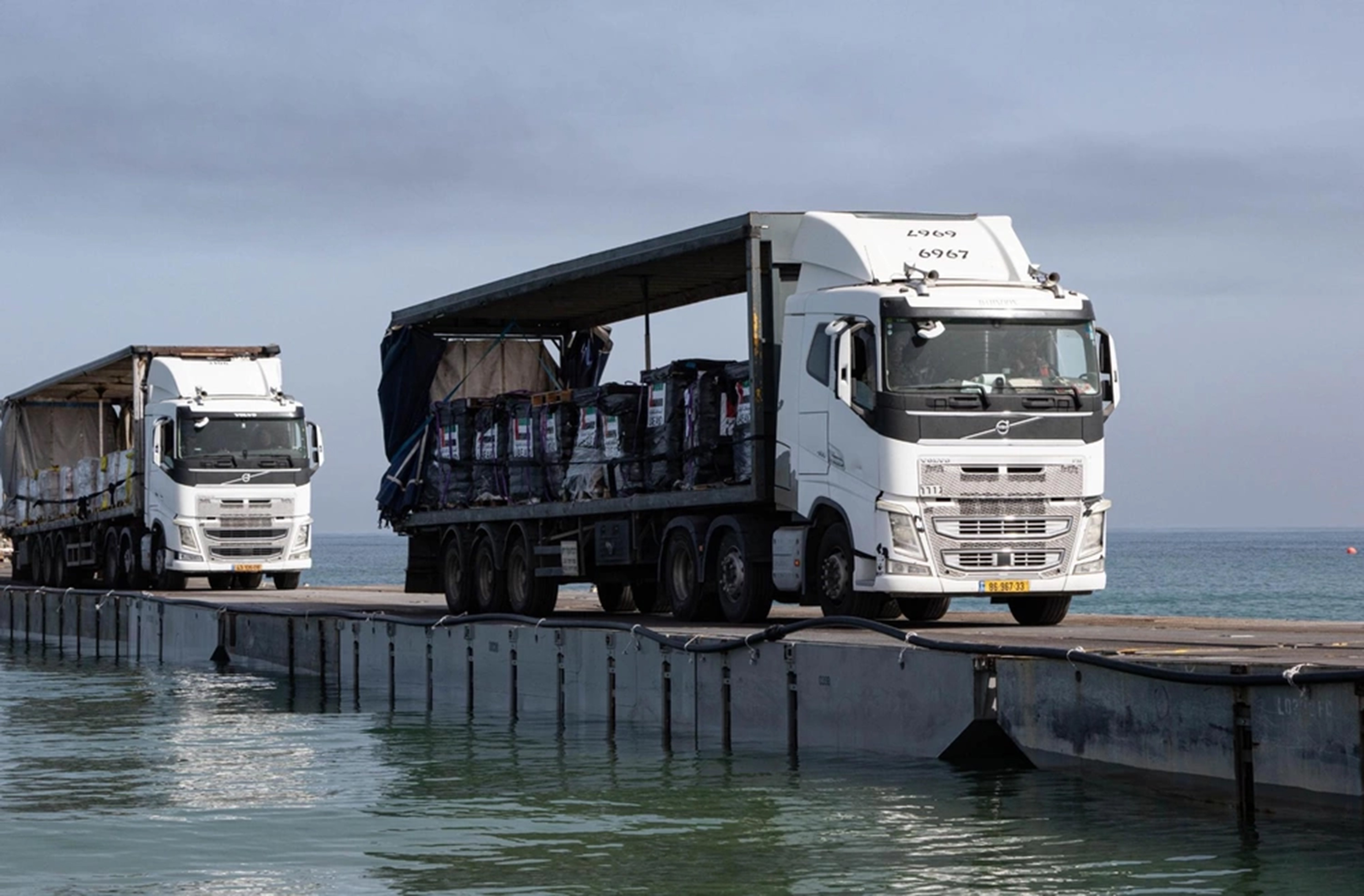 Trucks loaded with humanitarian aid from the United Arab Emirates and the United States Agency for International Development cross the Trident Pier before entering the beach in Gaza. Photo / US Army Central via AP