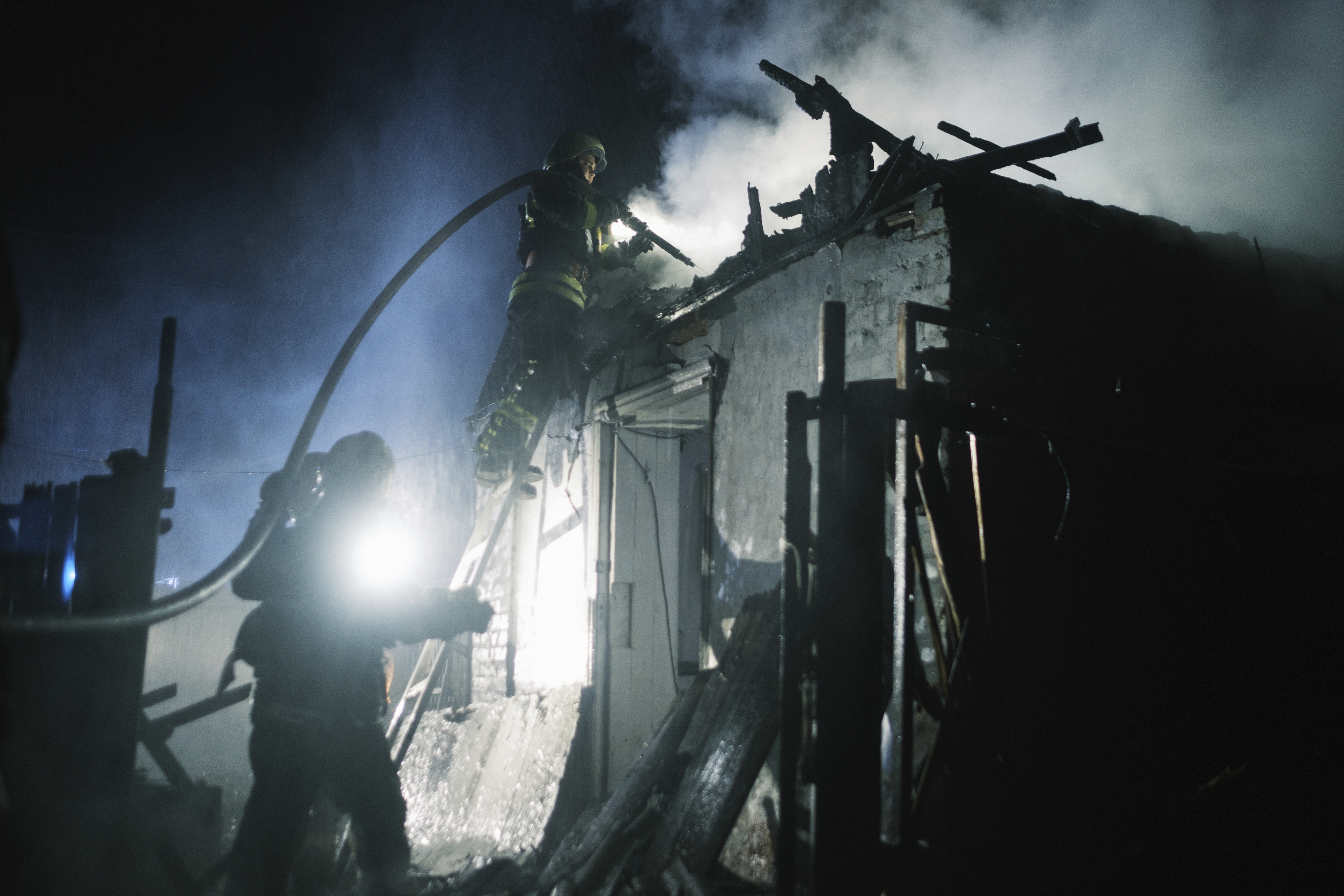 Ukrainian rescue workers extinguish a house fire. Photo / AP