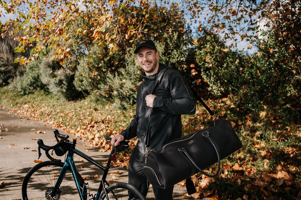 Track athlete Sam Dakin modeling a duffle bag from Honest Wolf's The Team New Zealand collaboration, made with recycled New Zealand wool from Papanui Estate.