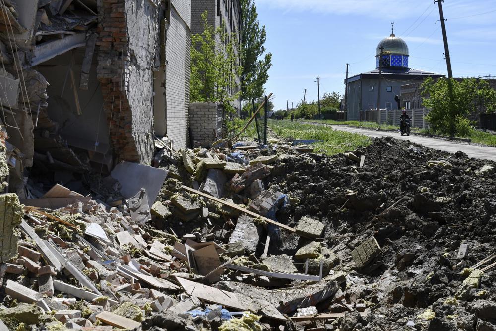 A crater of an explosion after Russian shelling is seen next to a damaged apartment building in Bakhmut, Donetsk. Photo / AP