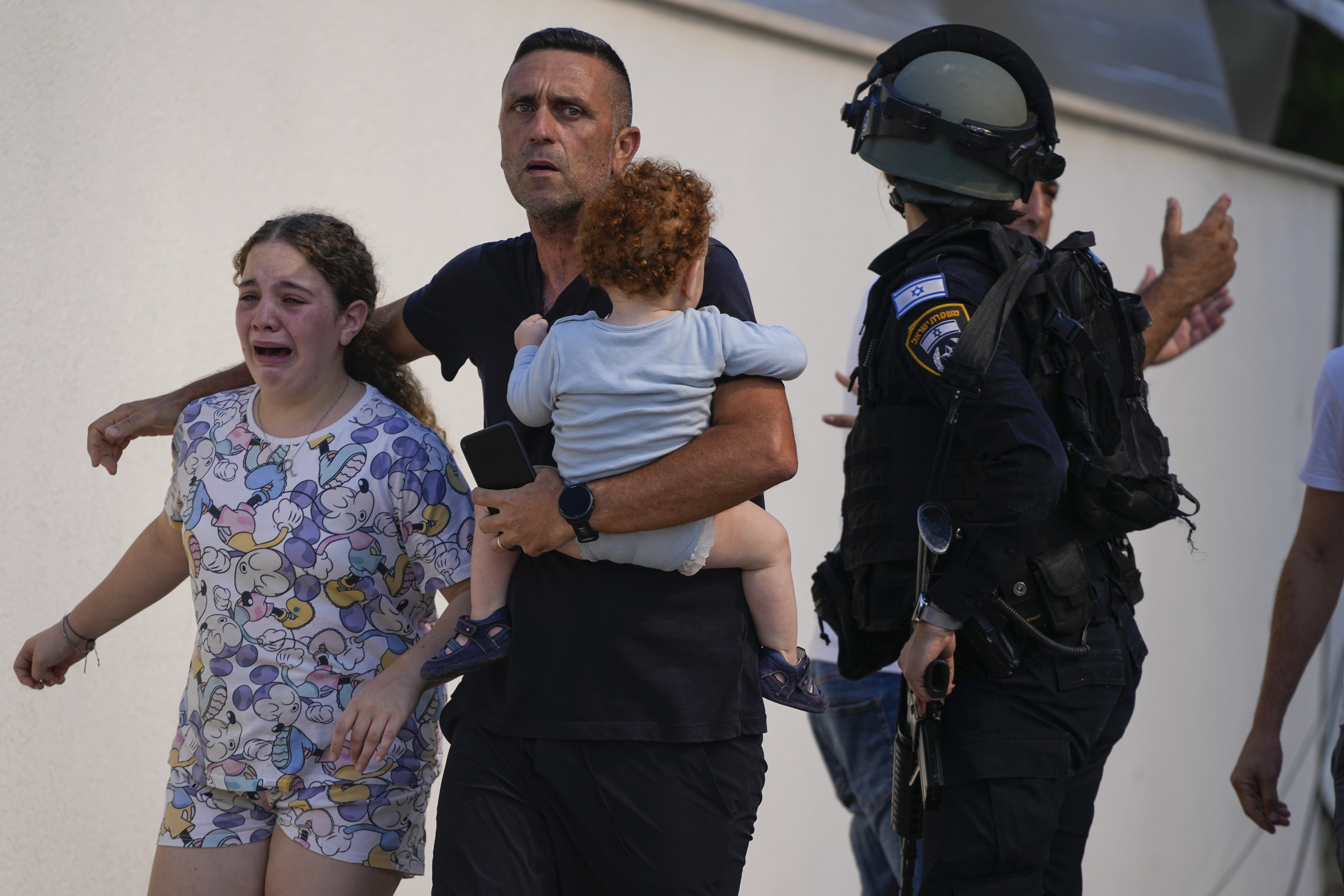 Israeli police officers evacuate a family from a site hit by a rocket fired from the Gaza Strip. Photo / AP
