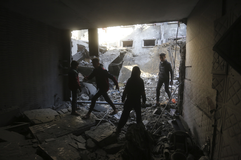 Palestinians look at the destruction after an Israeli strike in Rafah, Gaza Strip on December 24. Photo / AP