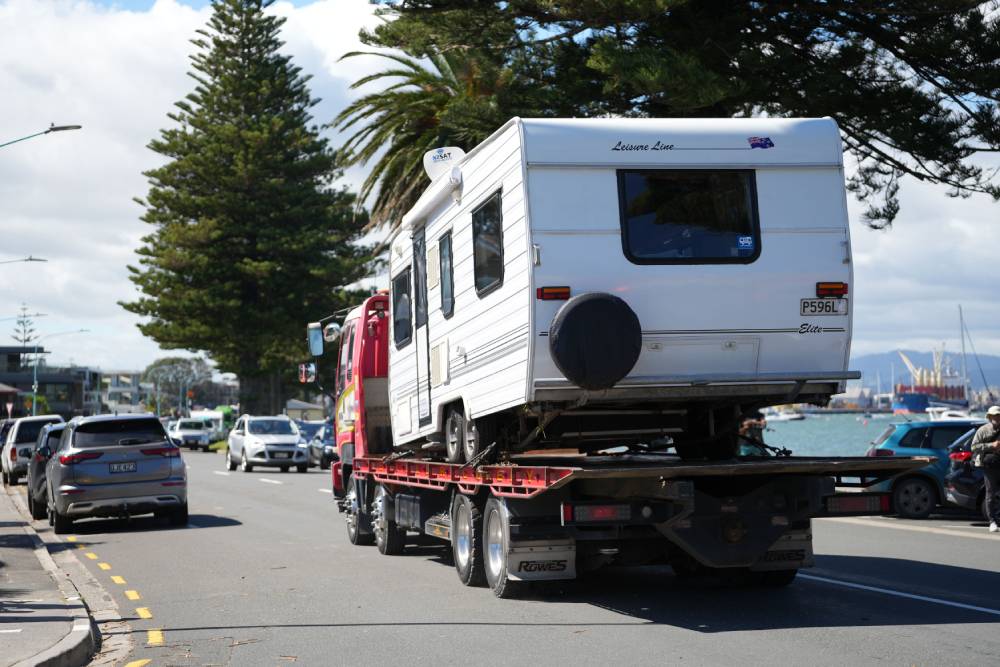 A campervan leaves the Mount Maunganui Beachside Holiday Park on the back of a tow truck two days after the deadly slip. Photo / Alyse Wright