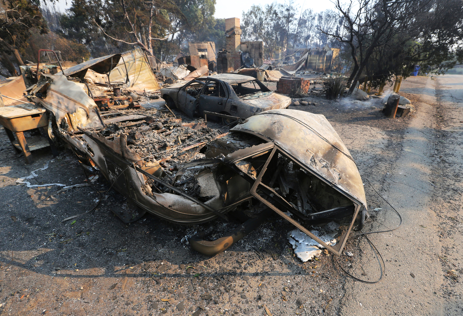 Vehicles and a home are in ruins, one of at least 20 homes that were lost on Windermere Drive. Photo / AP