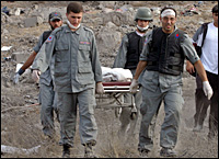 Medics carry the body of a boy who was killed, along with 9 family members, during a raid on southern Lebanon. Picture / Reuters