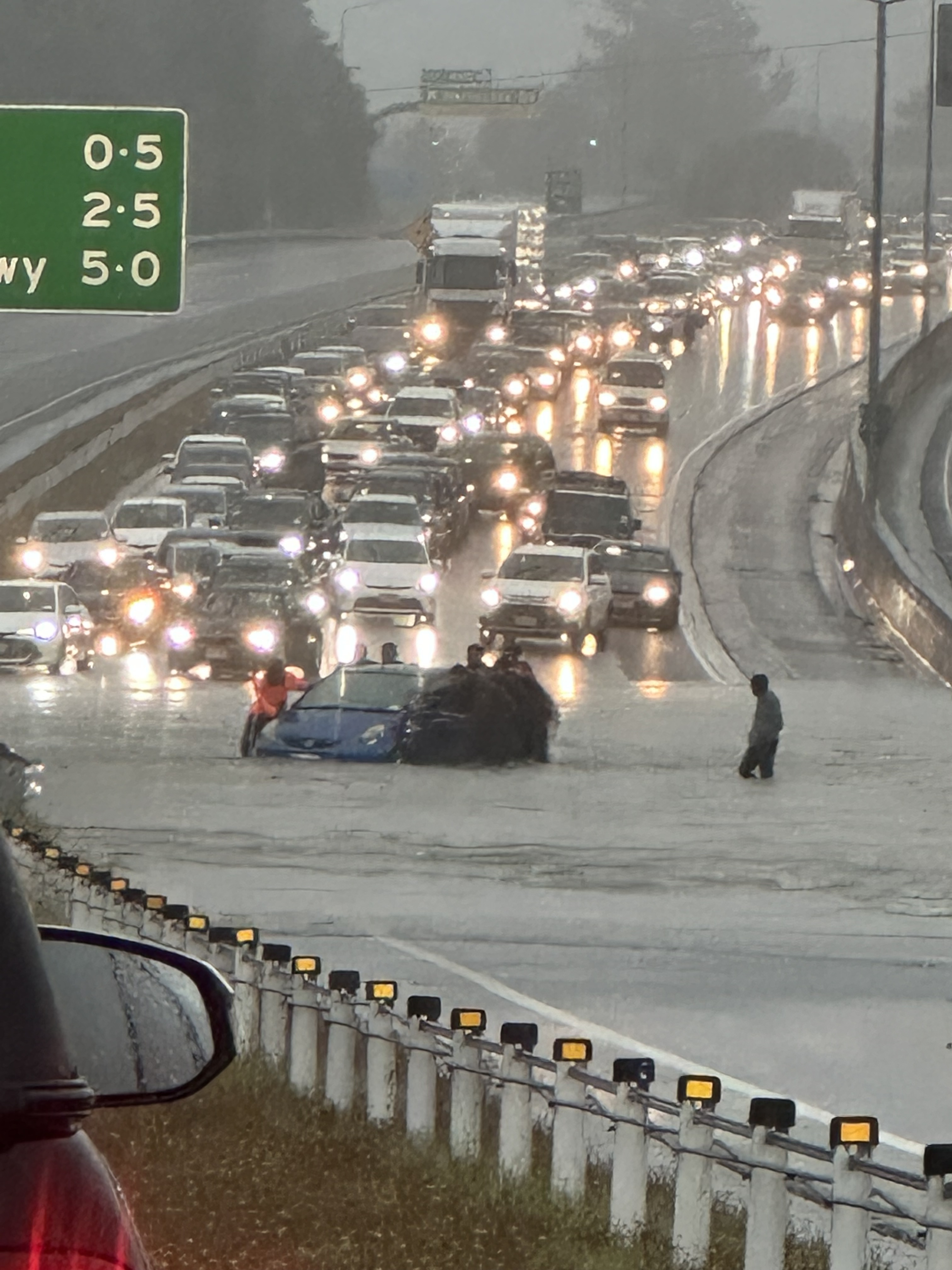 A car has been trapped in flooding on Auckland's northern motorway as rising water brings traffic going in both directions to a standstill. Photo / Supplied