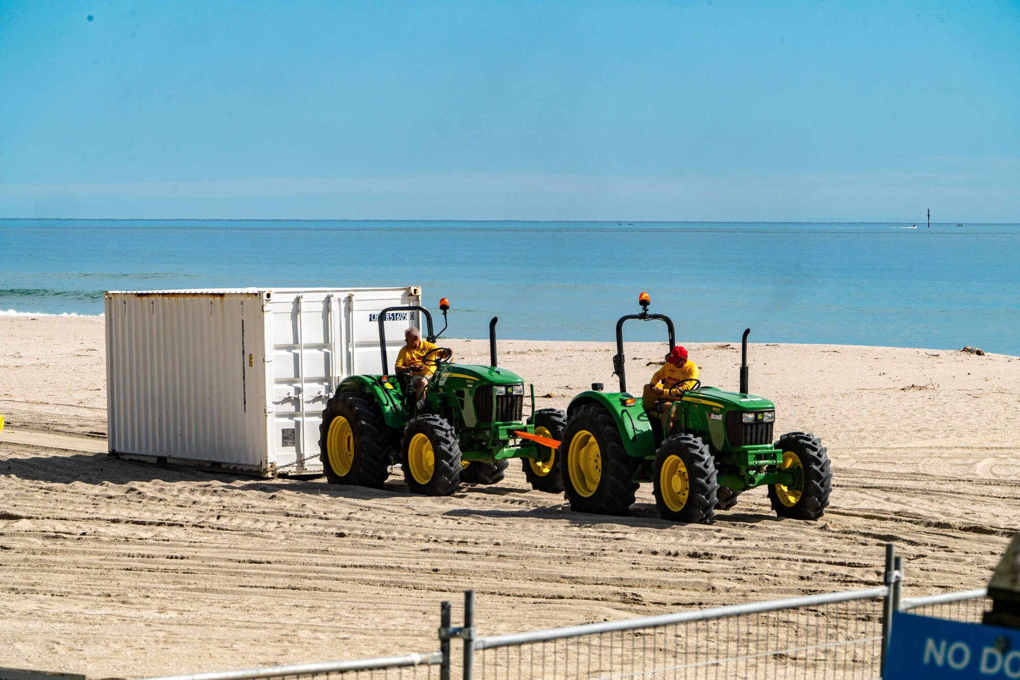 Tractors dragged a shipping container down the beach away from the surf club. Photo/ Corey Fleming