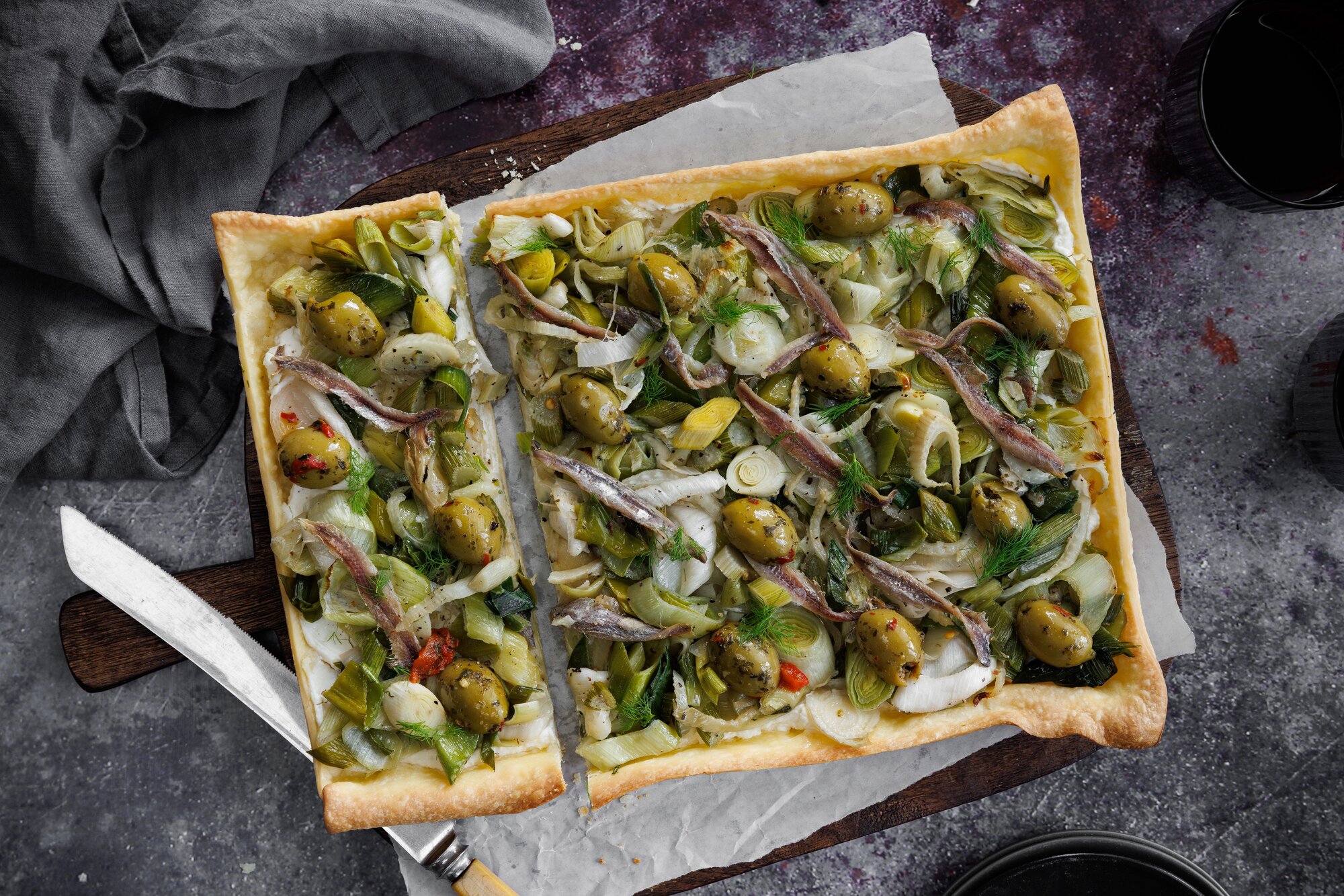 Begin with a sufficiently salty leek, fennel and olive tart. Photo / Babiche Martens