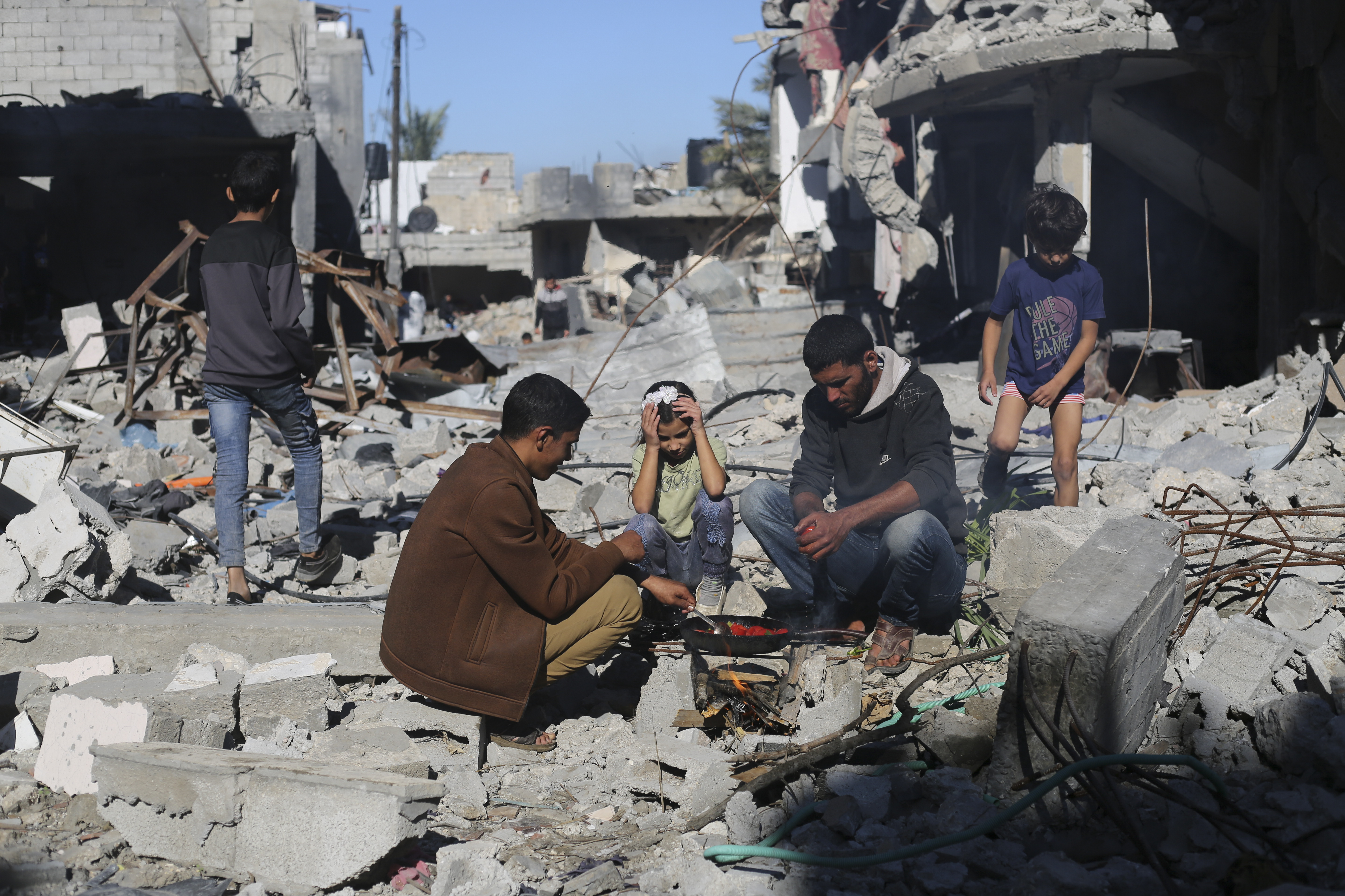 Palestinians cook bread by their destroyed homes in the Gaza Strip during the temporary ceasefire. Photo / AP