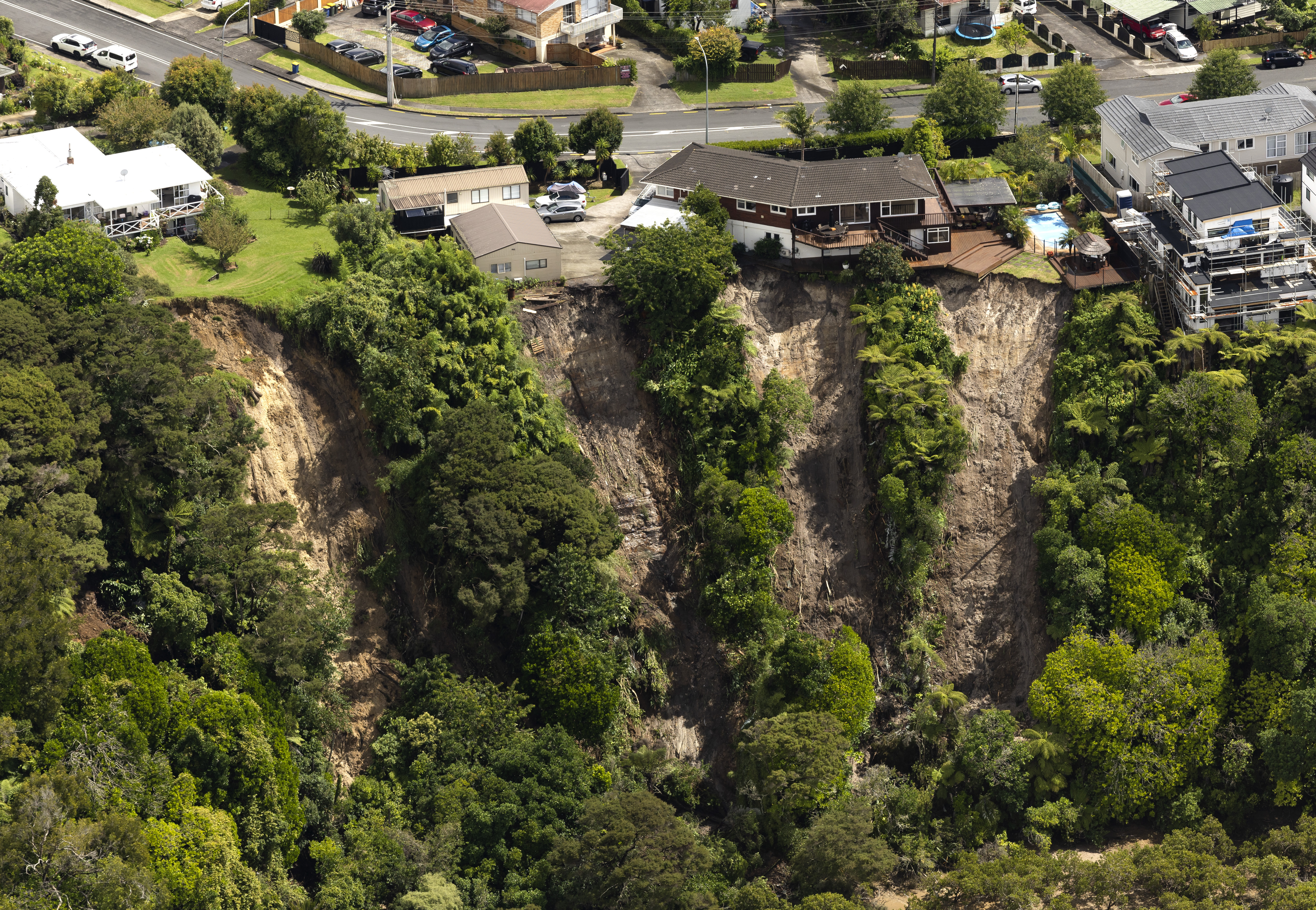 Hanging on the edge - landslides threaten homes on Colwill Road, Massey. Photo / Brett Phibbs