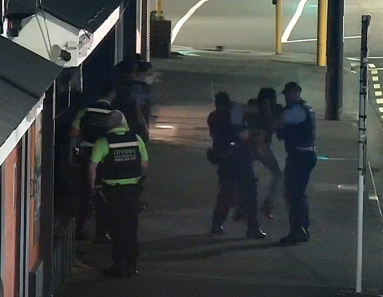 Jamie Lawry is lifted from the ground after being handcuffed by police in 2022. 