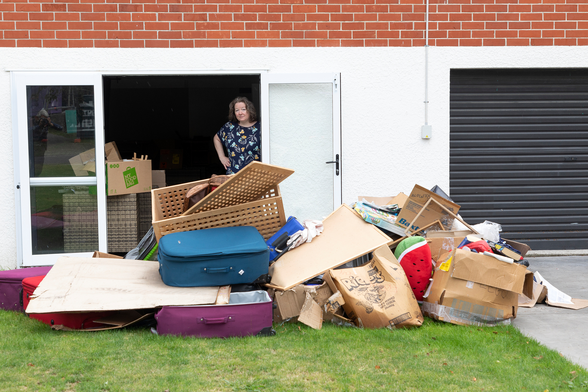 Ceryn Hutin outside her Glenholme home with flood-damaged household items. Photo / Andrew Warner