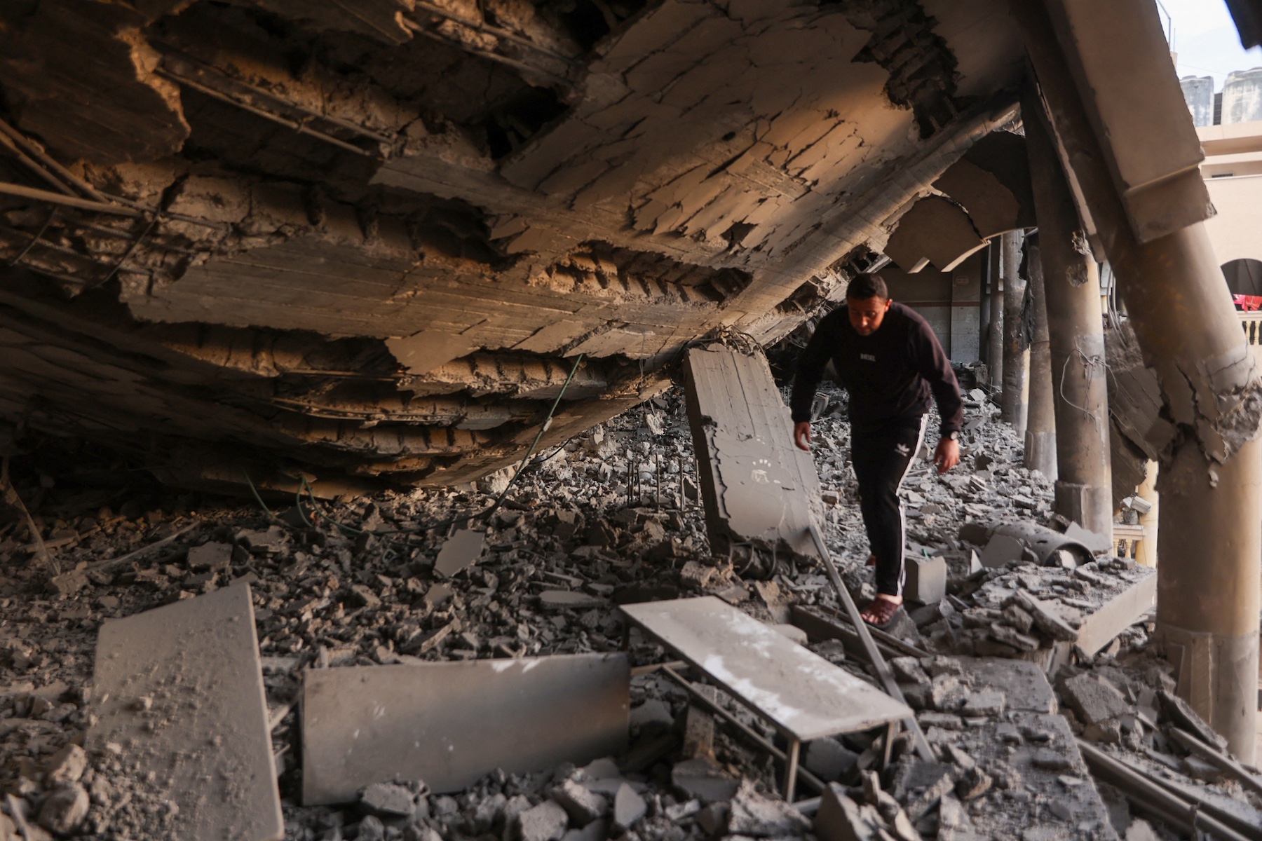 A man walks through the rubble of a destroyed section of a school-turned-camp following an Israeli strike in Gaza City yesterday. Photo / AFP
