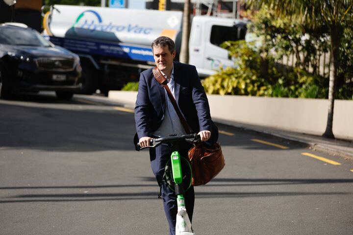 National Party MP Chris Bishop arrived by e-scooter at the party gathering. Photo / Michael Craig