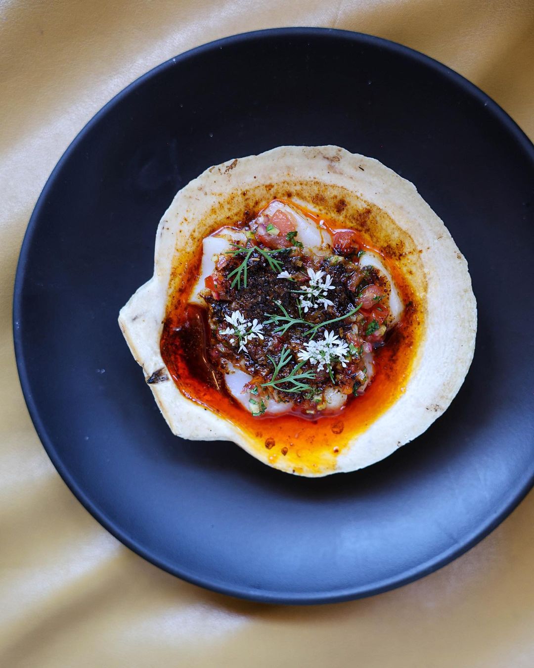 Scallop gratin comprising bone marrow chilli oil, salata arabieh, cumin, sumac, lime, and coriander at Bavel restaurant. Photo / @Baveldtla