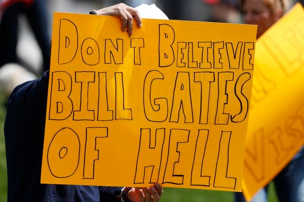 A protester holds up a sign against U.S. business mogul and philanthropist Bill Gates. Photo / AP