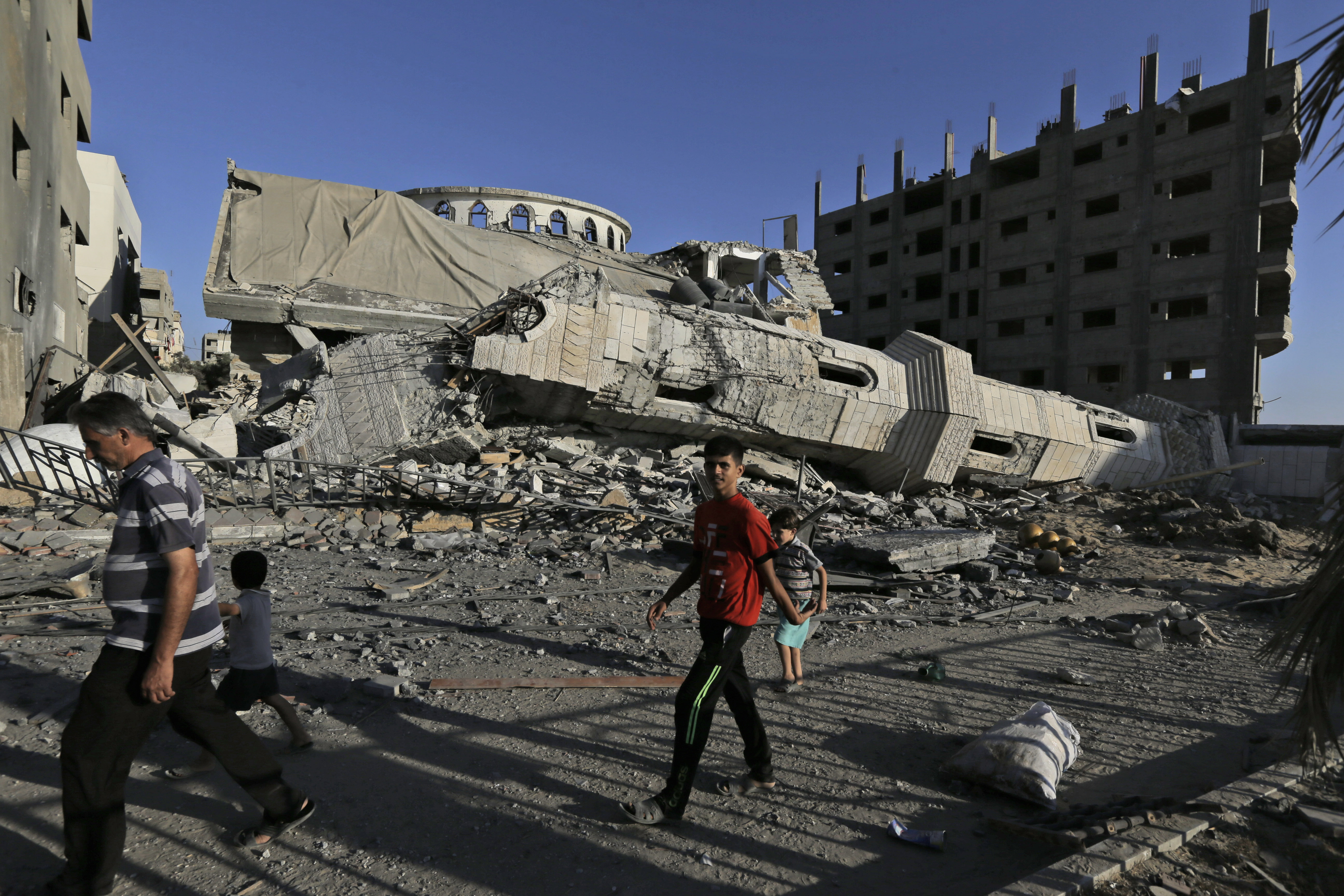 Palestinians walk by the rubble of the toppled minaret of the Abu Jihad Al Wazer mosque, destroyed by an Israeli strike during the war, in Gaza City. Photo / AP