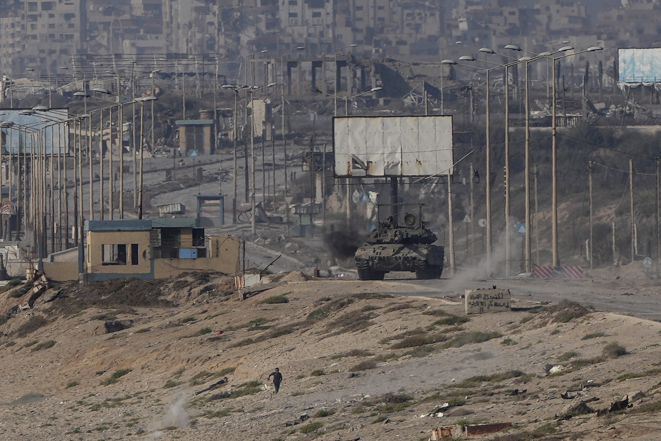 A Palestinian runs away from an Israeli tank in the central Gaza Strip. Photo / AP