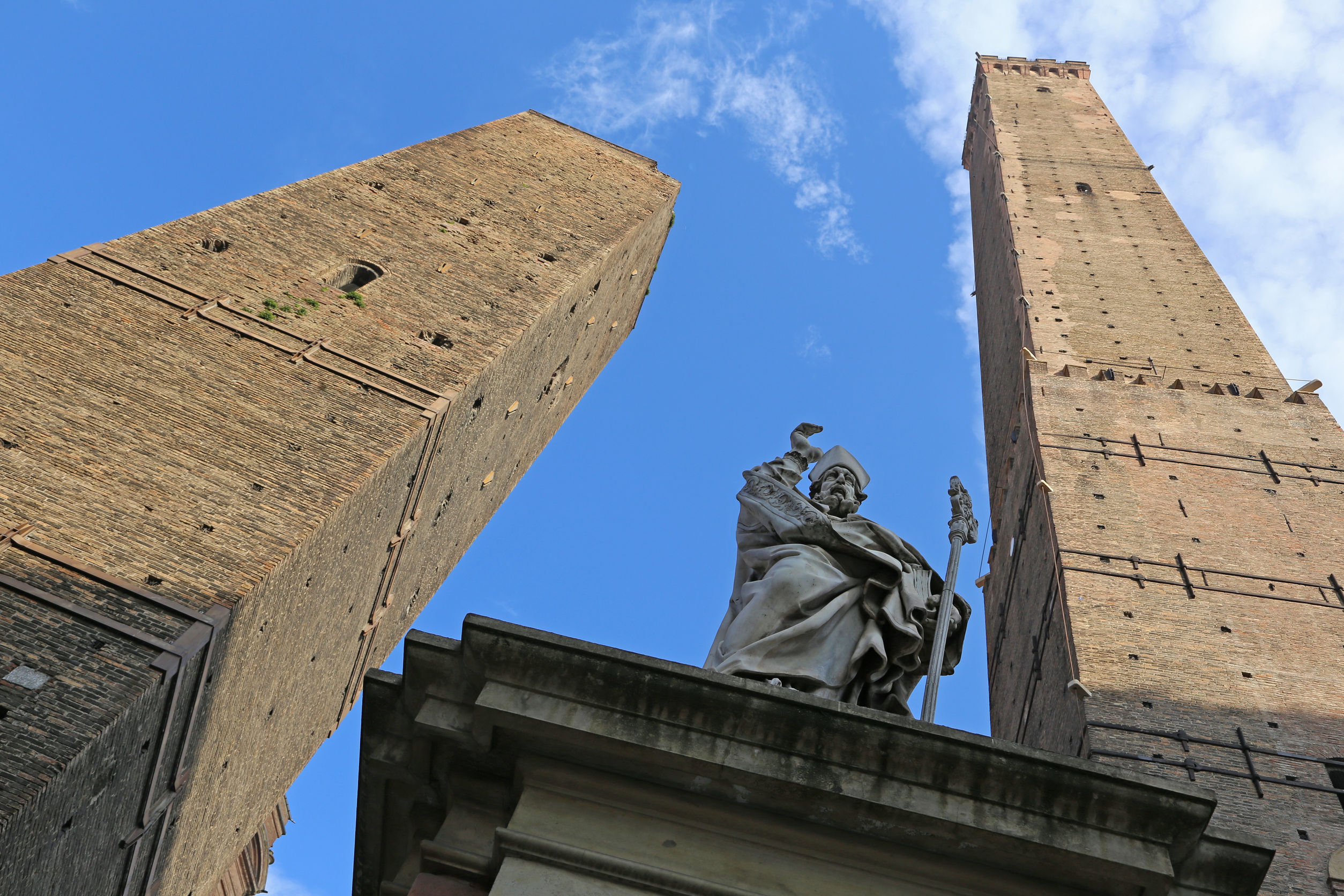 Torre Asinelli and Torre Garisenda towers and statue of St Petronio tower over Bologna. Photo / 123Rf