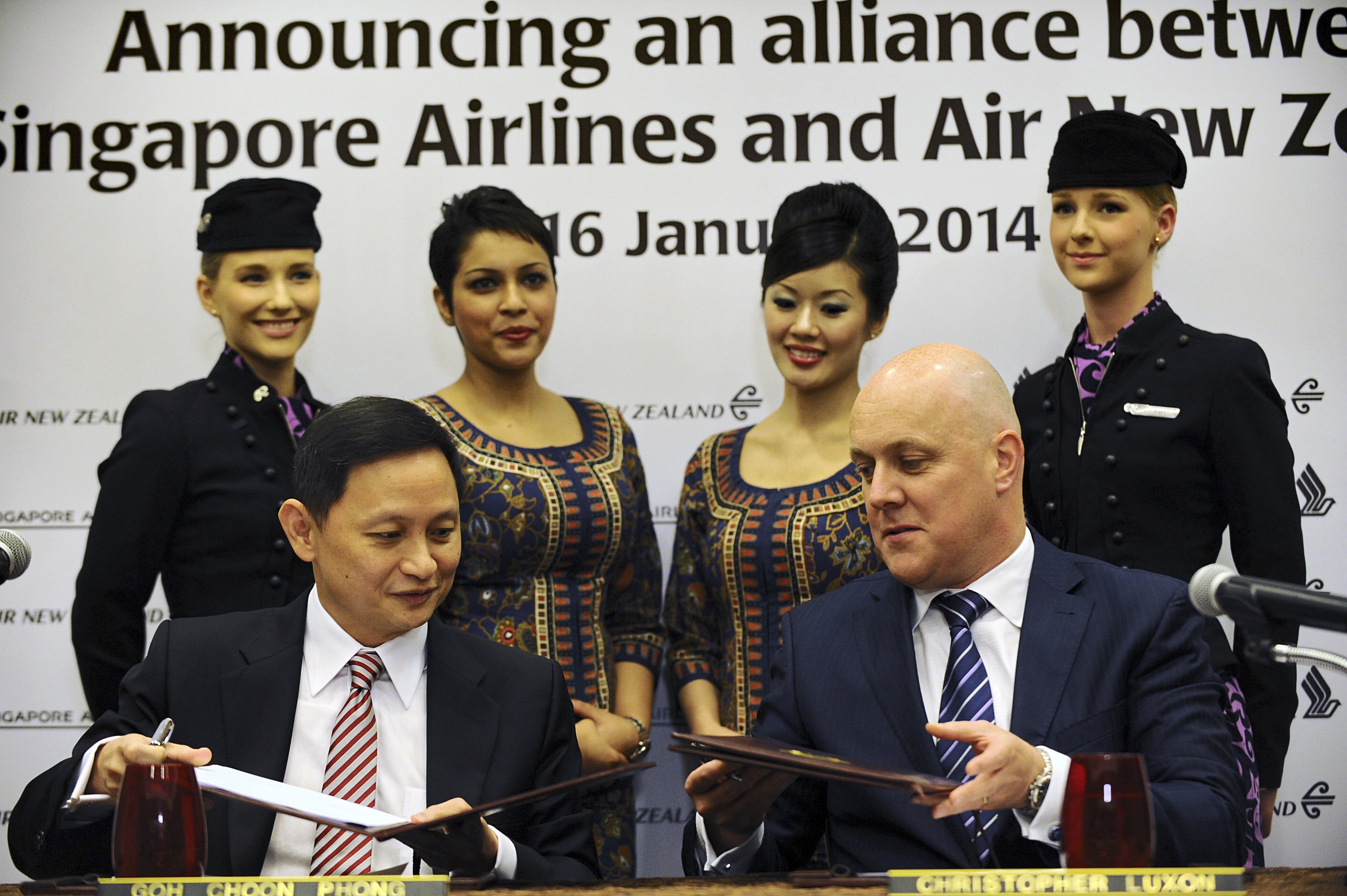 Negotiating agreements: Singapore Airlines chief executive Goh Choon Phong (L) and Air New Zealand chief executive Christopher Luxon (R) sign an alliance agreement in Singapore on January 16, 2014. Photo / Getty Images