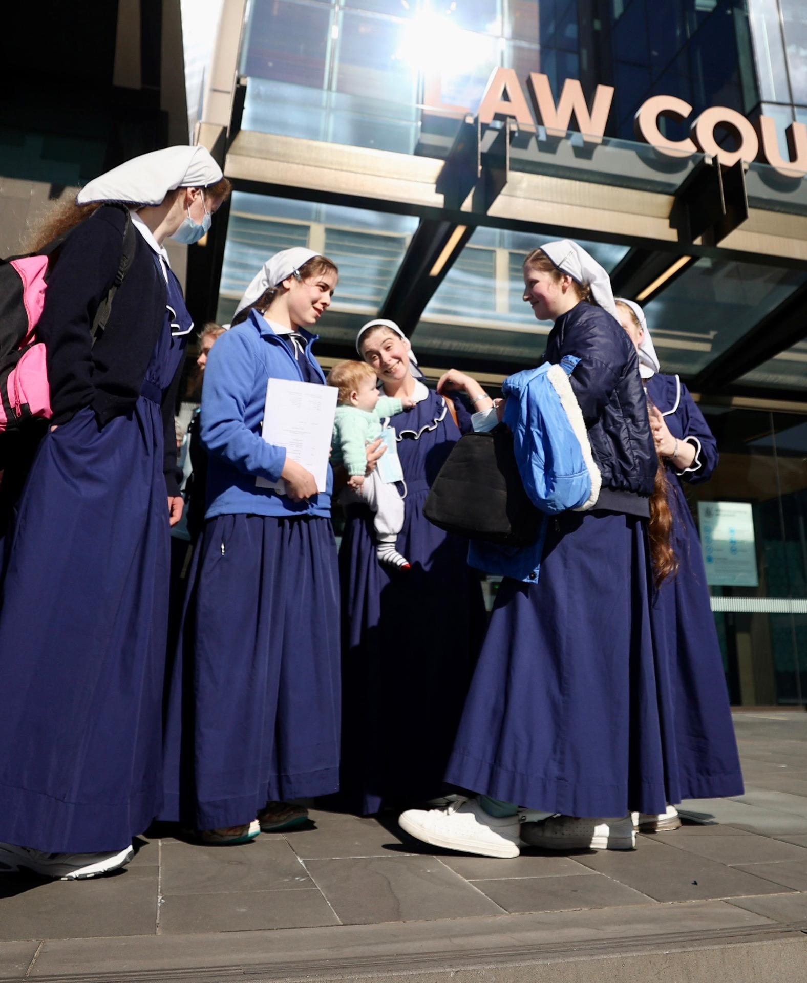 Gloriavale members outside the Christchurch Ōtautahi District Court. Photo / George Heard