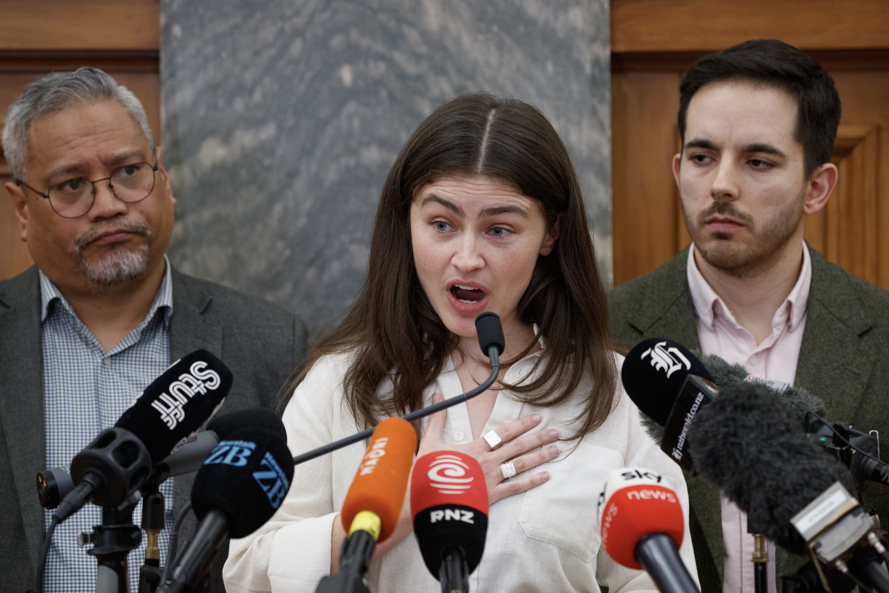 Green Party co-leader Chlöe Swarbrick, with colleagues Teanau Tuiono and Ricardo Menendez March, speaking about Tana in Parliament on Monday. Photo / Mark Mitchell   