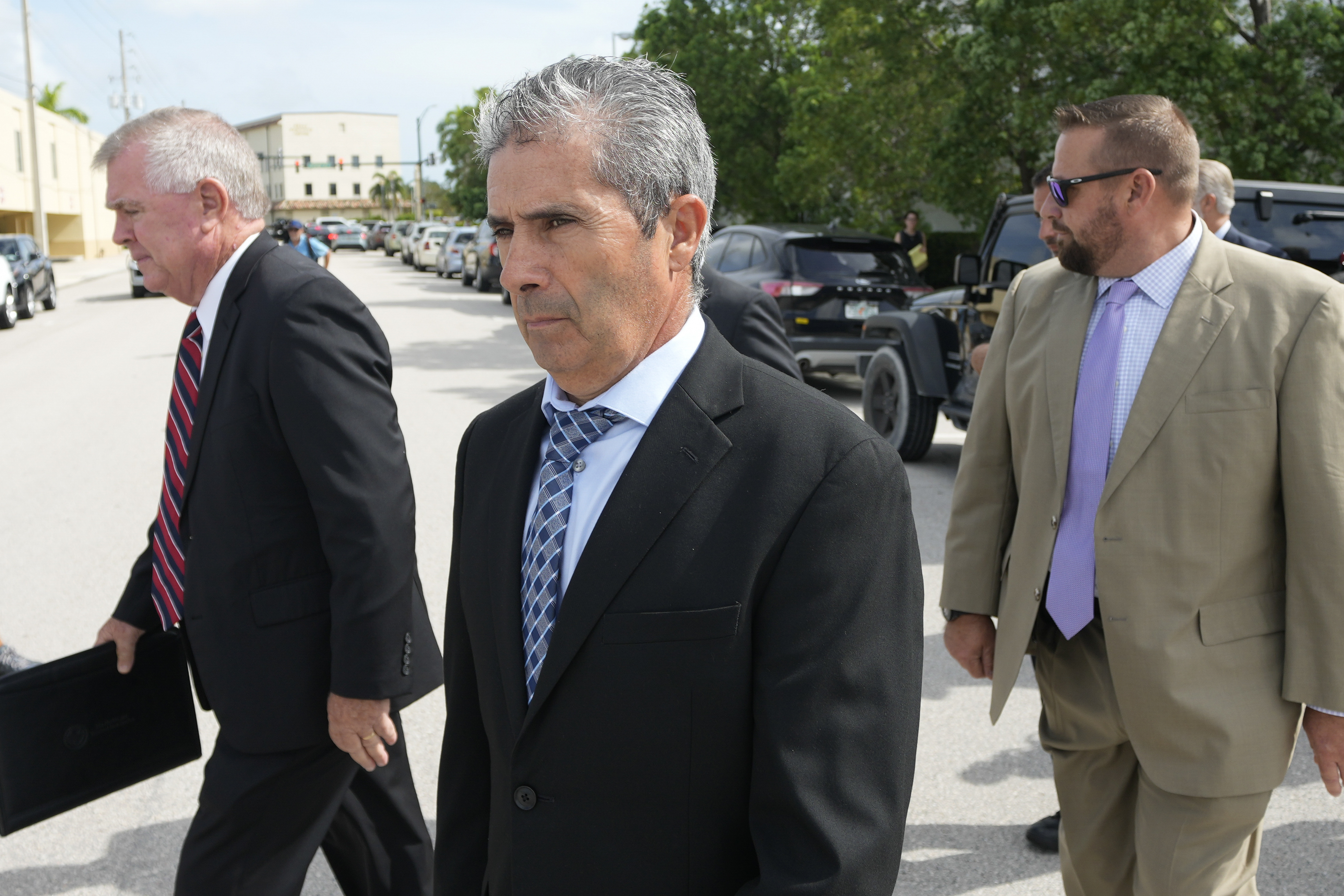 Carlos De Oliveira (centre), property manager of former president Donald Trump's Mar-a-Lago estate, leaves court after his arraignment hearing. Photo / AP