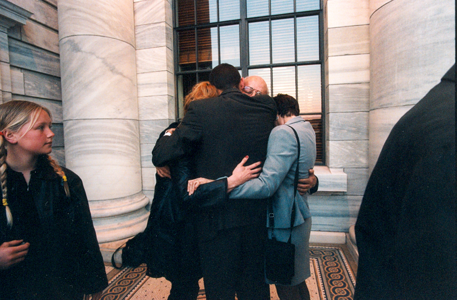 Tā Tipene O'Regan hugs whānau members outside Parliament after the final reading of the Ngāi Tahu Claims Settlement Bill, 1998. 
