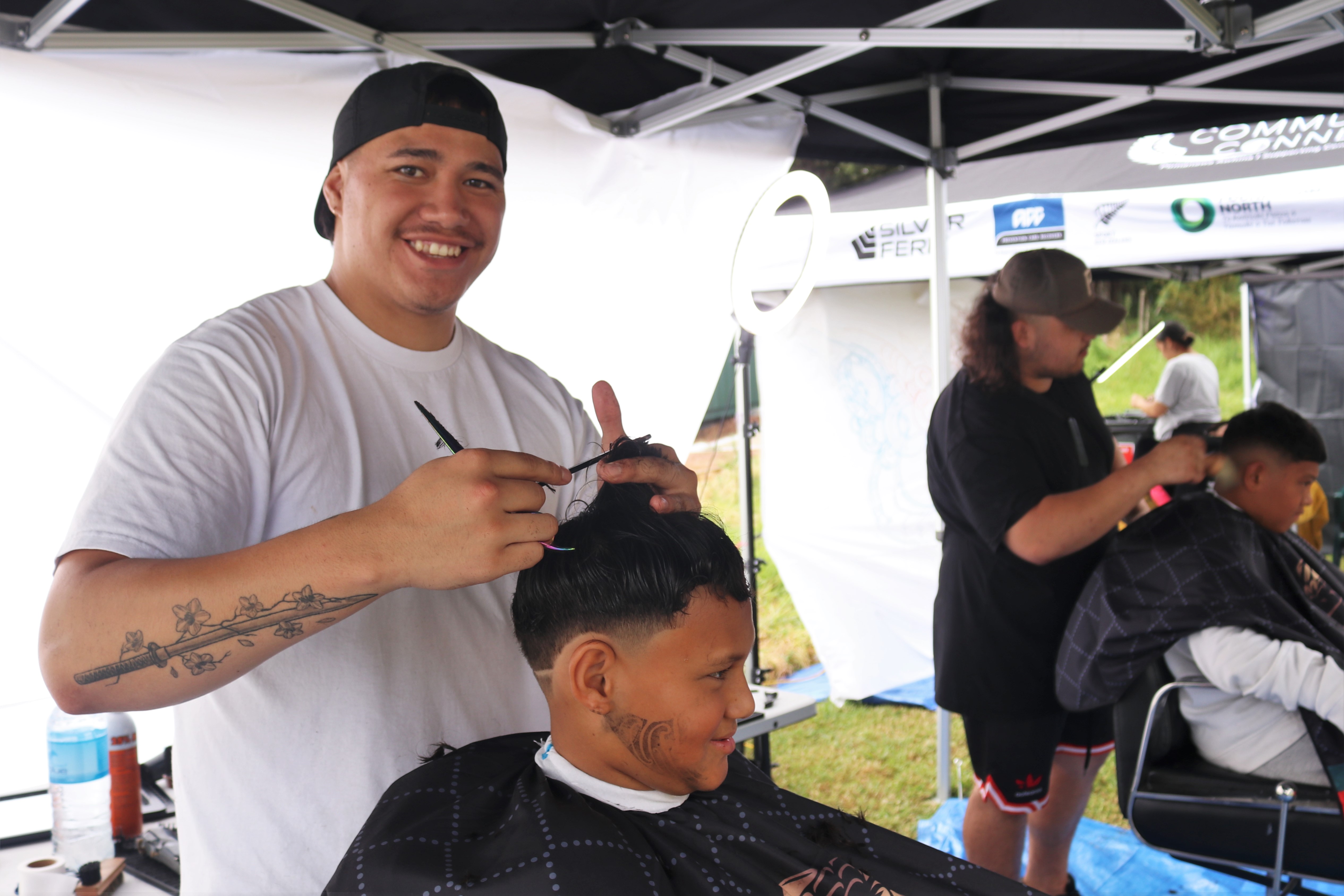 Tamarangi Haunui-Tipene, owner of YNG Barbershop in Moerewa, gives a free cut to 11-year-old Vayton Ngawati. Photo / Peter de Graaf
