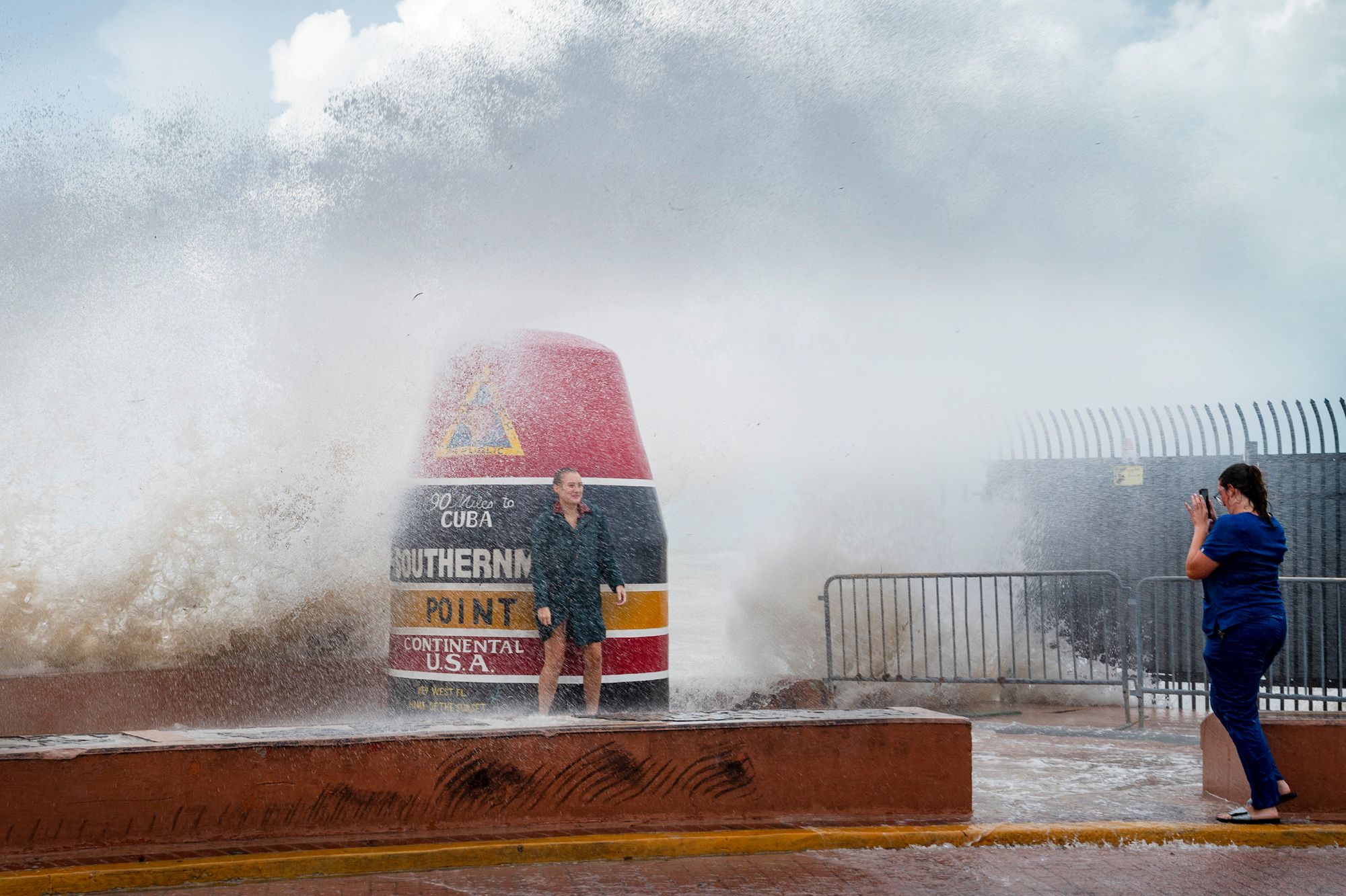 Visitors to the Southernmost Point buoy braved the waves made stronger from Hurricane Idalia in Key West yesterday. Photo / AP