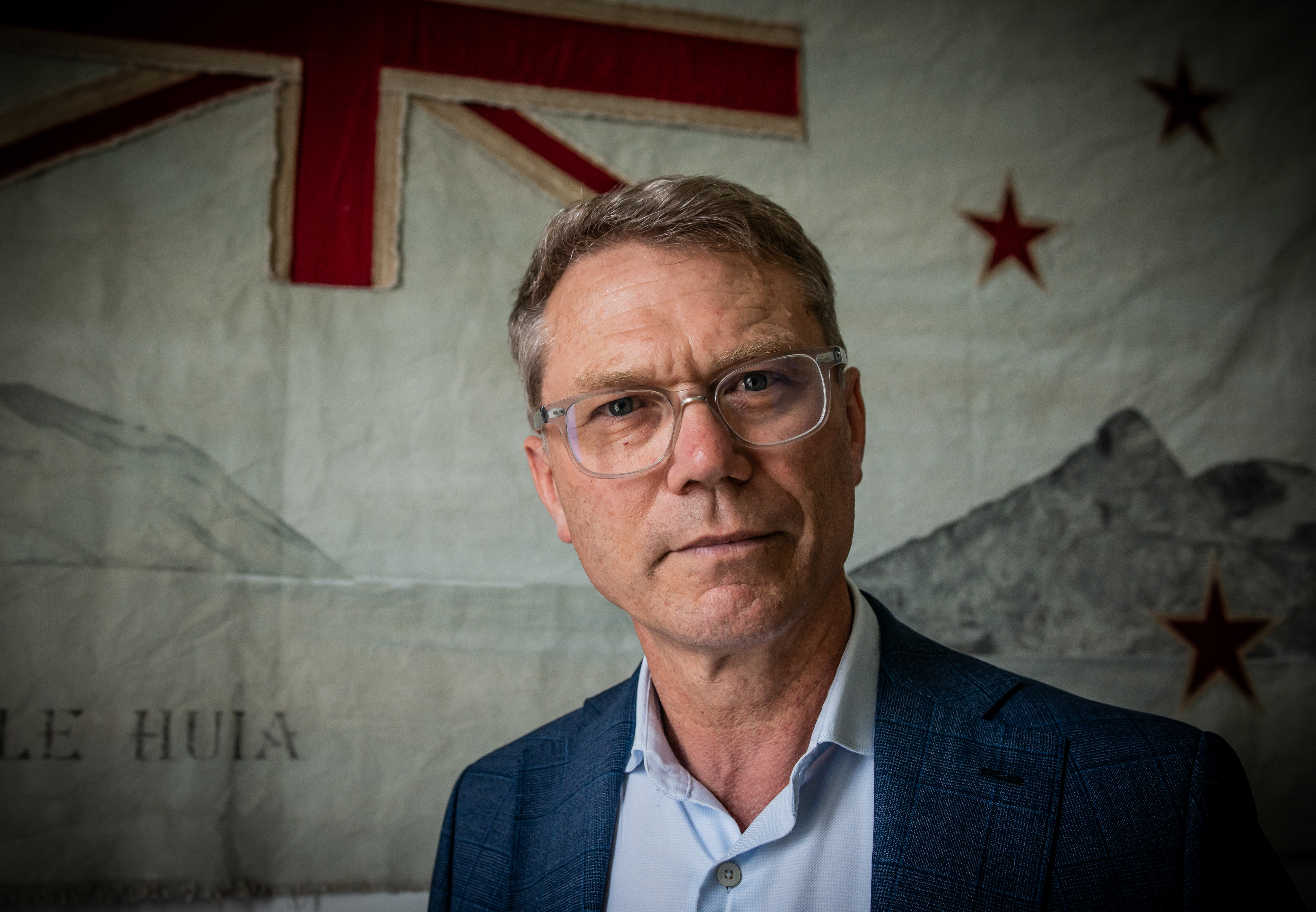 Paul Goldsmith at his Auckland home with a work from Paula Coulthard's Aotearoa flag series. Photo / Simon Young