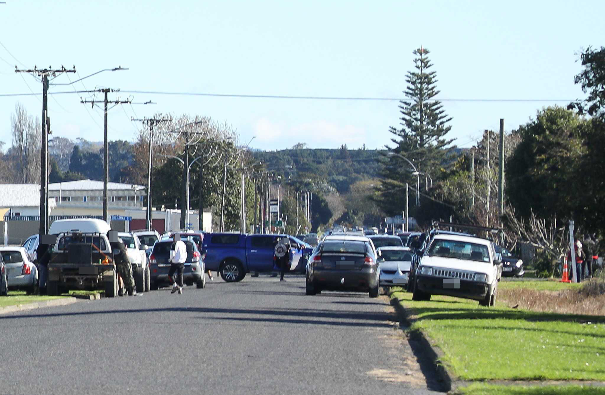 Gang members and vehicles line an Ōpōtiki street near an address where slain Mongrel Mob president Steven Rota Taiatini is believed to lie. Photo / NZME
