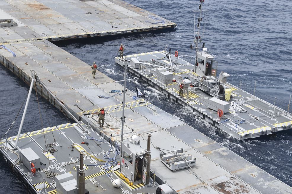 In this image provided by the US Army, soldiers assigned to the 7th Transportation Brigade (Expeditionary) and sailors attached to the MV Roy P. Benavidez assemble the Roll-On, Roll-Off Distribution Facility (RRDF), or floating pier, off the shore of Gaza on April 26, 2024. (U.S. Army via AP, File)