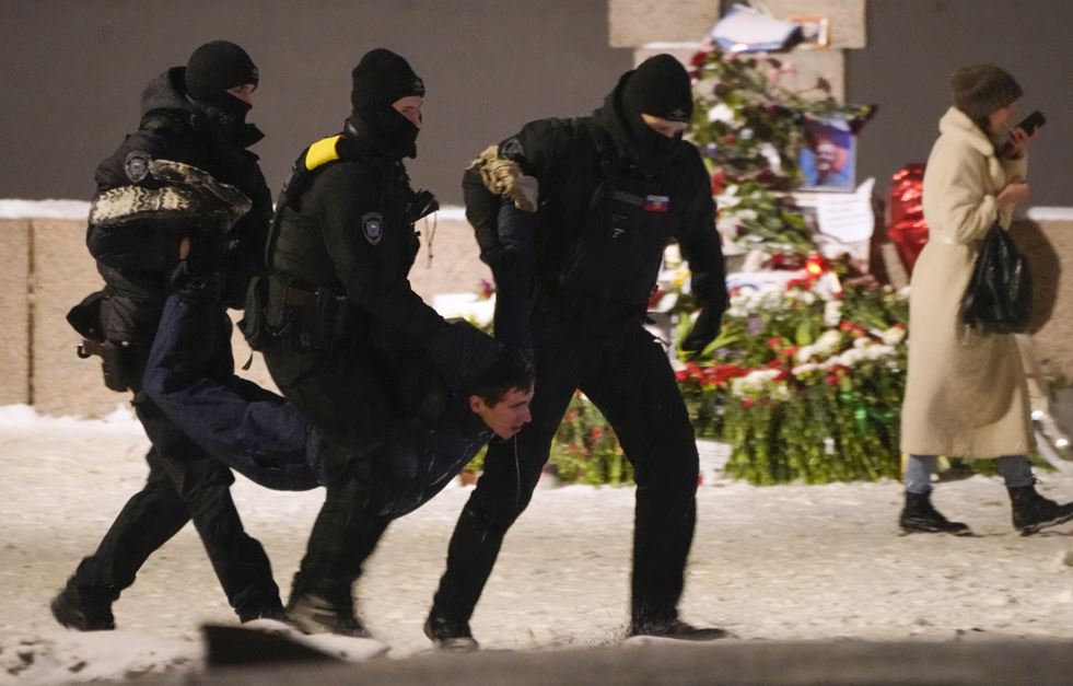 Police officers detain a man laying flowers to Alexei Navalny at the Memorial to Victims of Political Repression in St Petersburg, Russia. Photo / AP