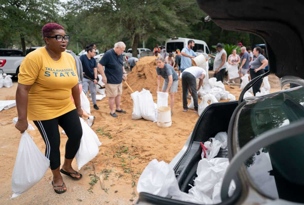 Tallahassee State professor Pamela Andrews carriers sand bags to a car in preparation for possible flooding as Tropical Storm Helene heads toward the state's Gulf Coast. Photo / Getty Images