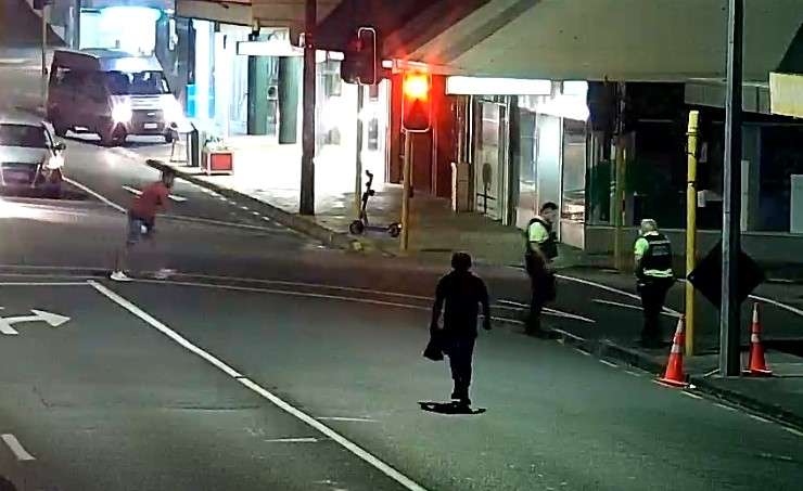 The man in the burgundy shirt (left) was pursuing City Safe officers until, in the foreground, Jamie Lawry stepped in.