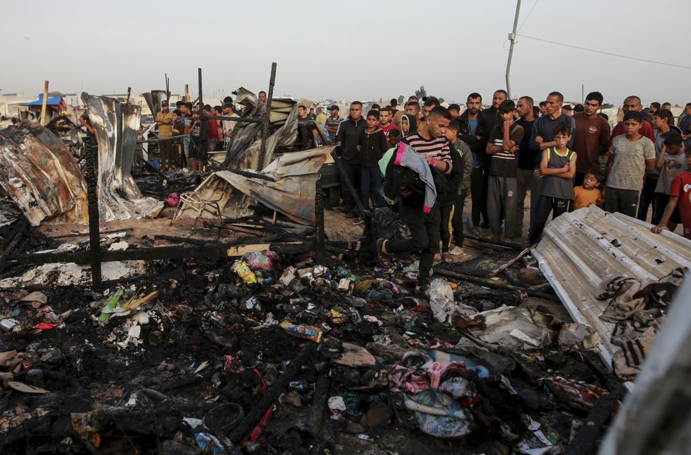 Palestinians look at the destruction after an Israeli strike where displaced people were staying in Rafah, Gaza Strip, on Monday. Photo / AP