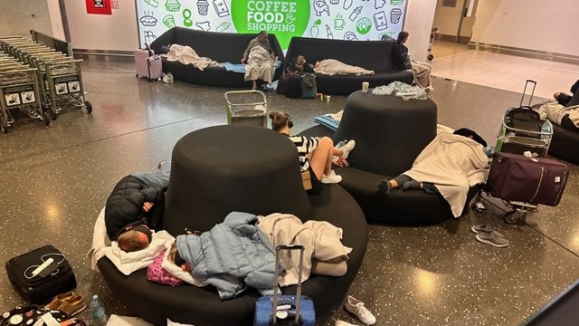Weary travellers bunker down try to get some sleep at Auckland Airport. Photo / Supplied